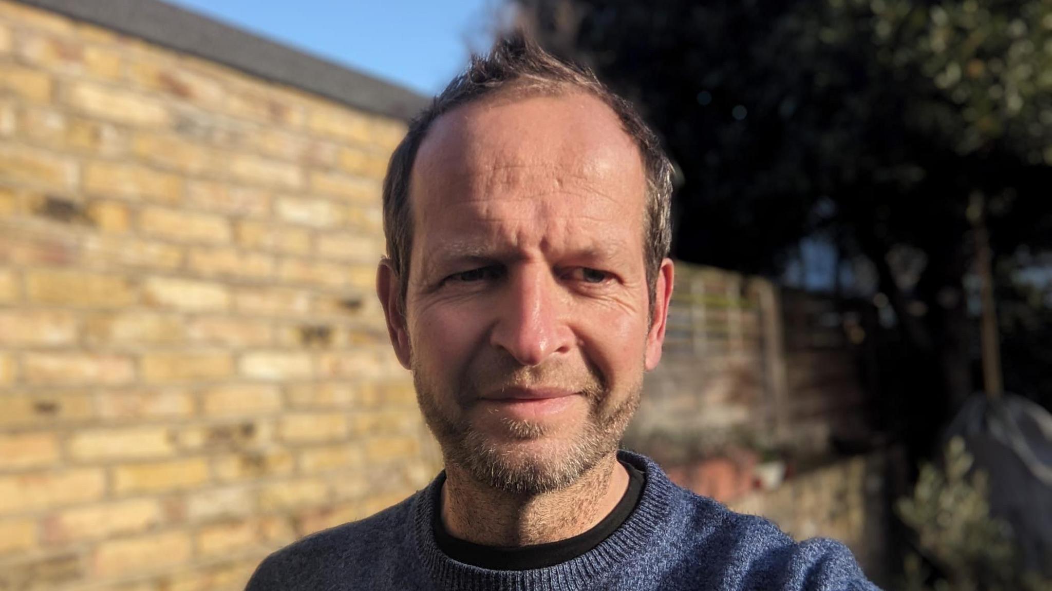 Campaigner Danny Prior is pictured in selfie, with his head and shoulders visible. Danny is around 40-60 years old, with short grey hair and a beard, wearing a blue jumper