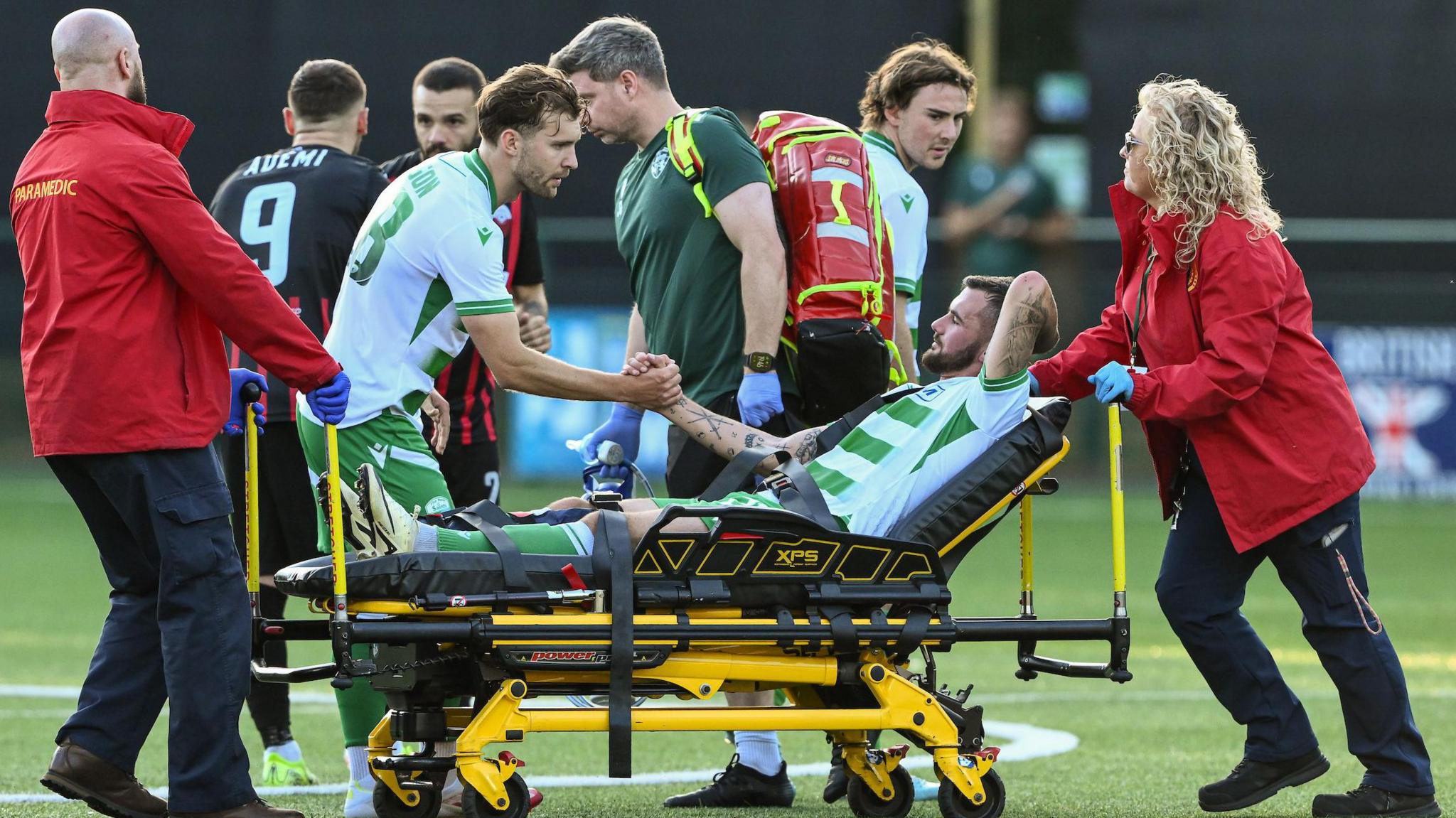 Leo Smith is consoled by New Saints team-mates as he is helped off
