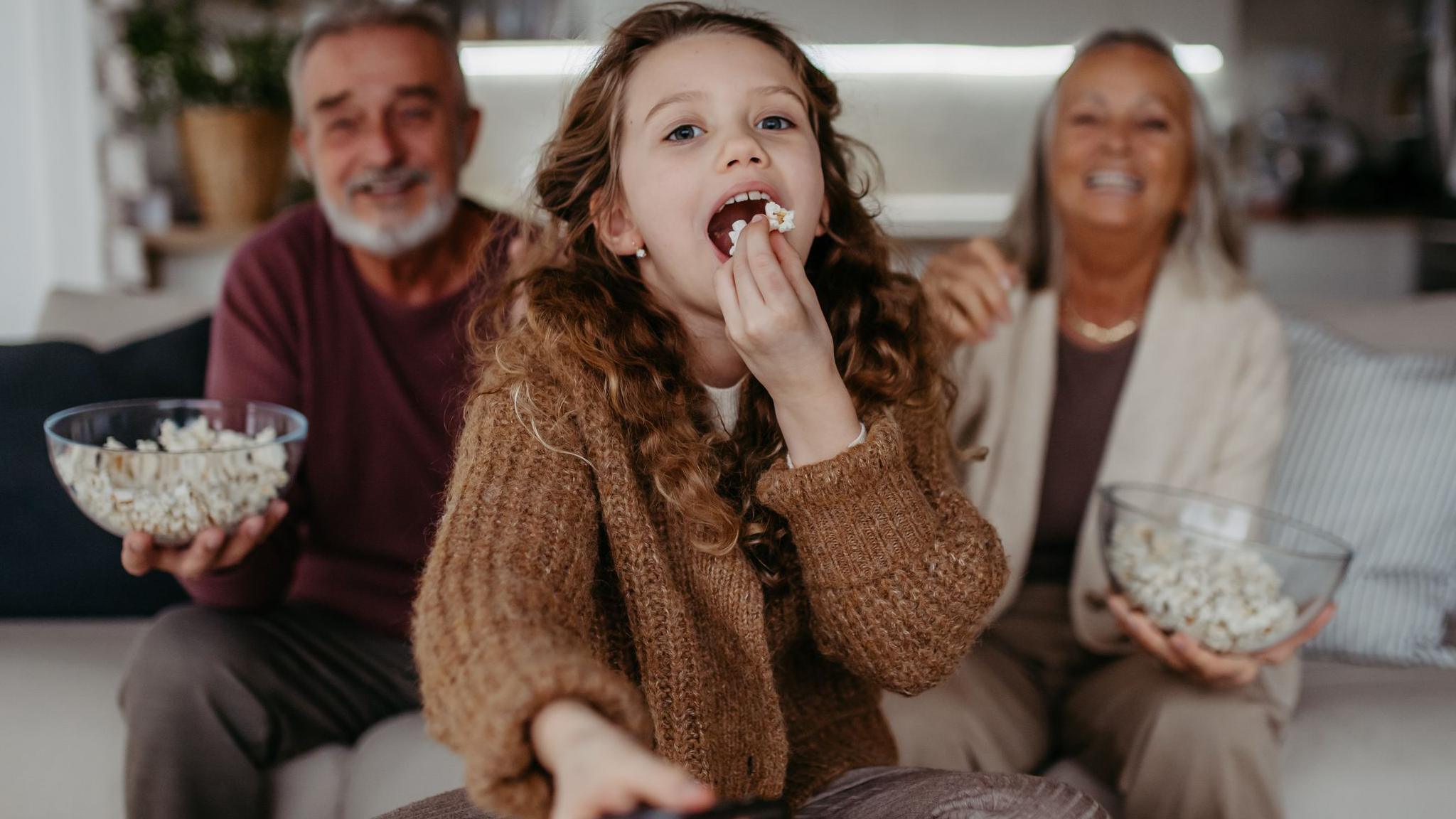 Girl and her grandparents watching TV 