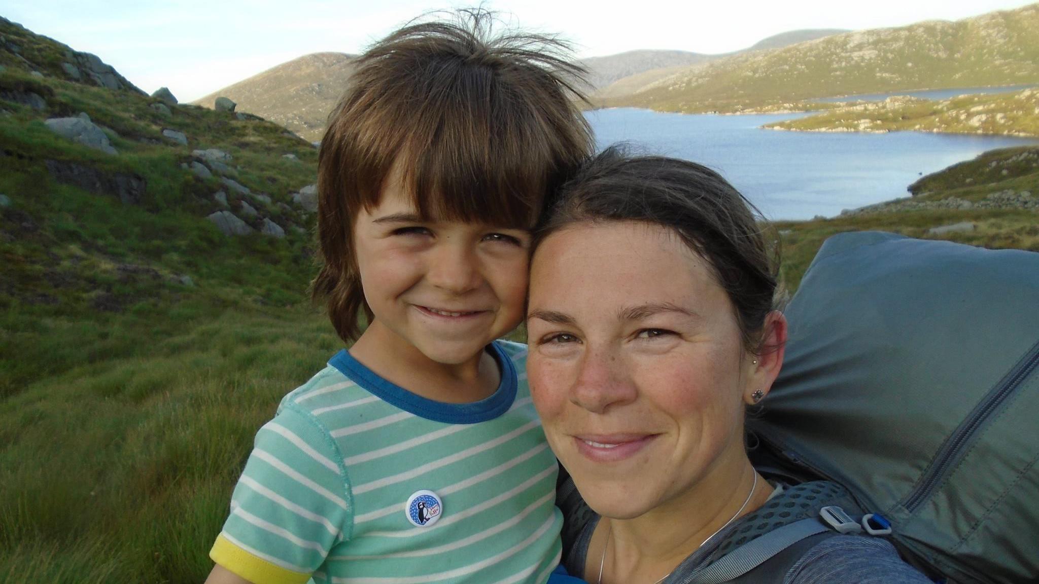 Finn and Kerry-Anne in Galloway Forest Park, they are both looking at the camera and there is a tent behind them