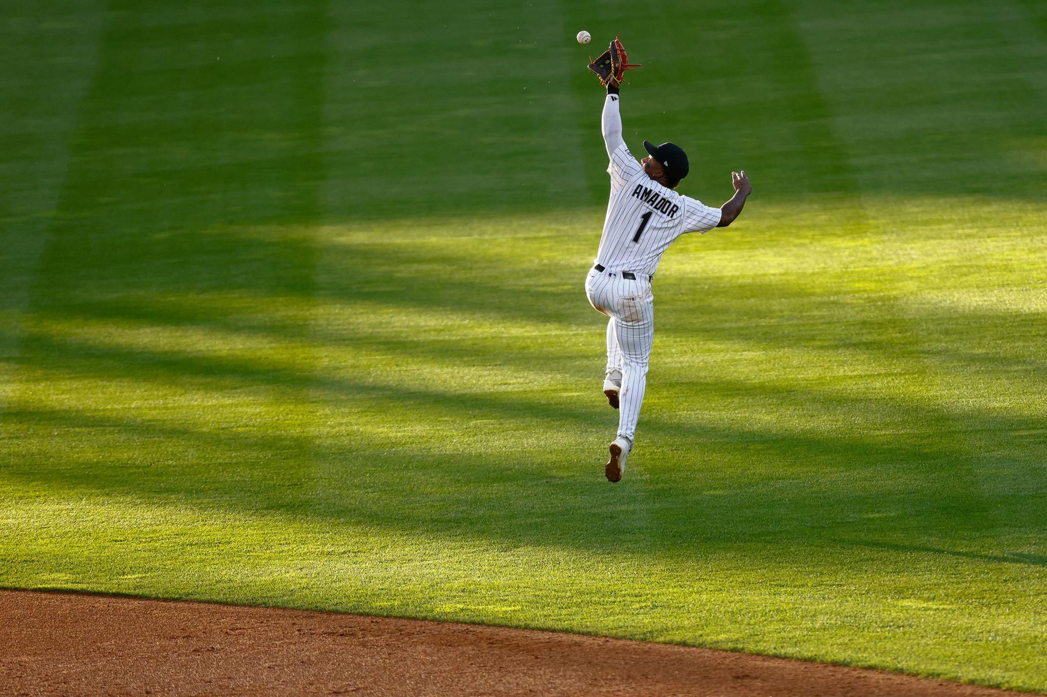 Colorado Rockies' Second baseman Adael Amador makes a leaping catch on a line drive to end the top of the third inning against the Philadelphia Phillies at Coors Field in Denver, Colorado. Photo by Justin Edmonds