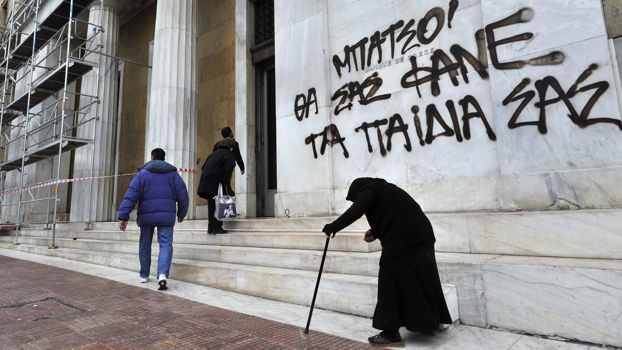 Lady begs outside Bank of Greece