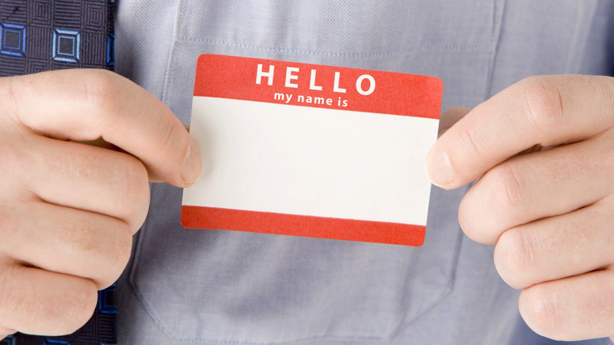 Man putting on "Hello - my name is" sticker