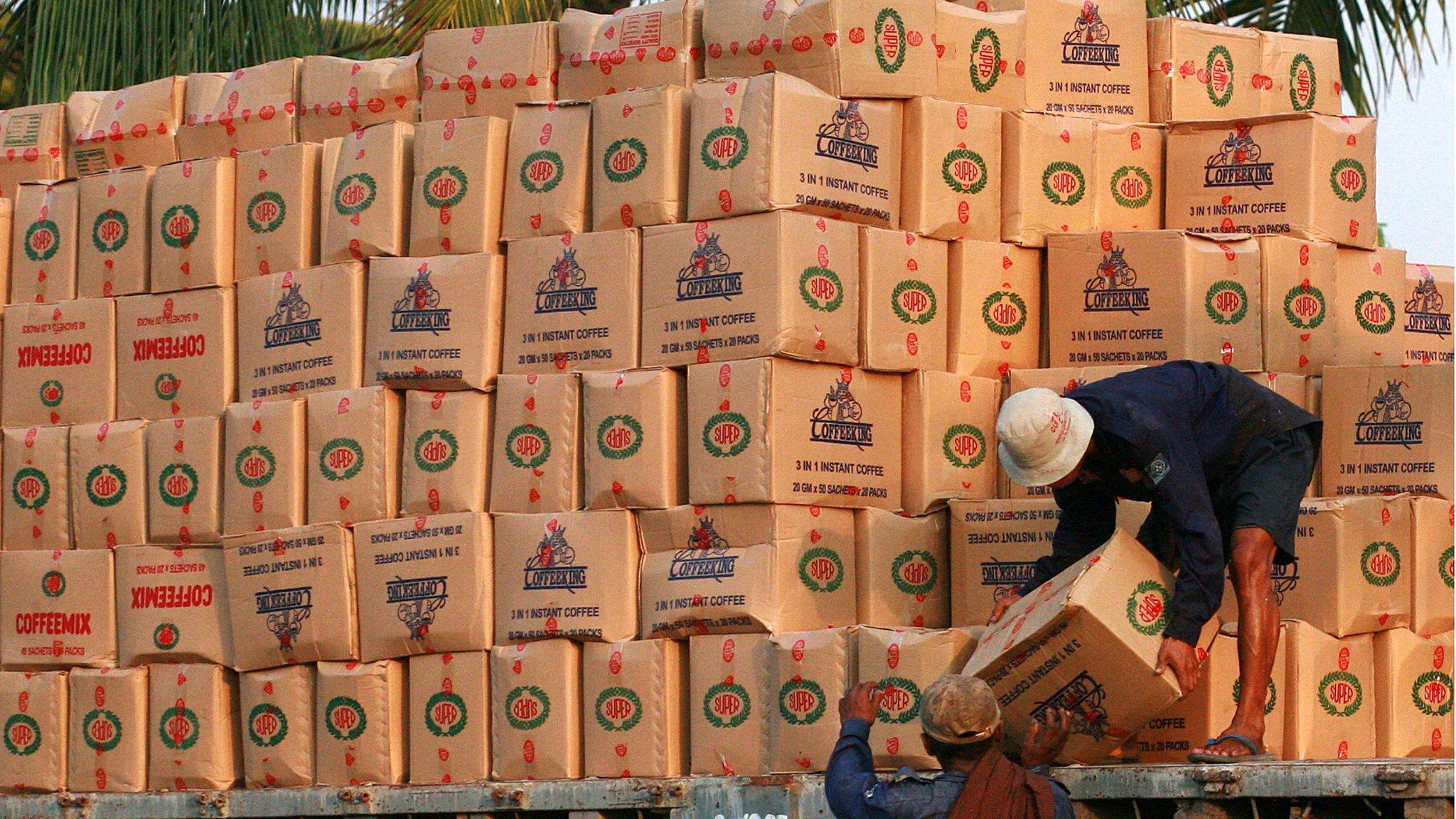 Workers load boxes of goods at the harbour in Rangoon