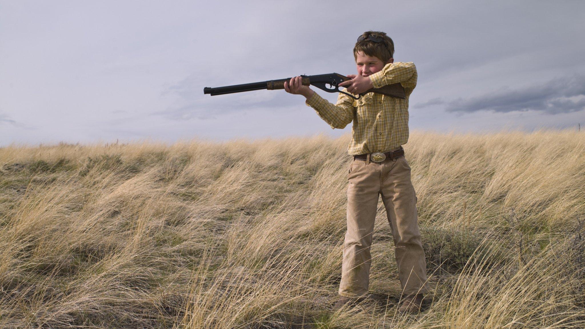 Boy with gun in a field