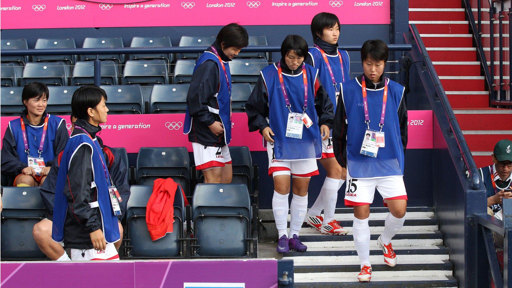 North Korean womens football team walking from seats in football stand