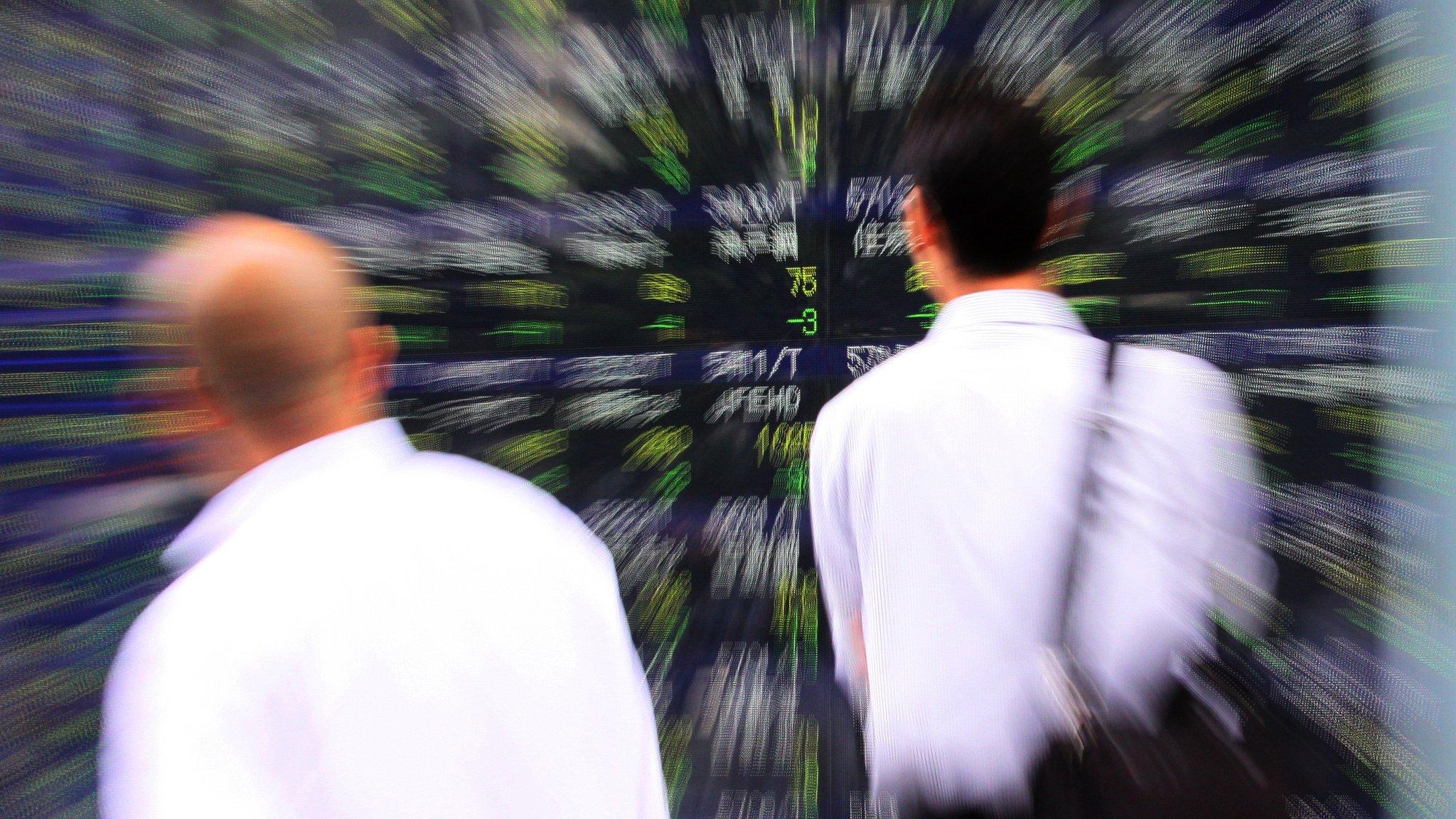 Investors looking at stock market board in Tokyo