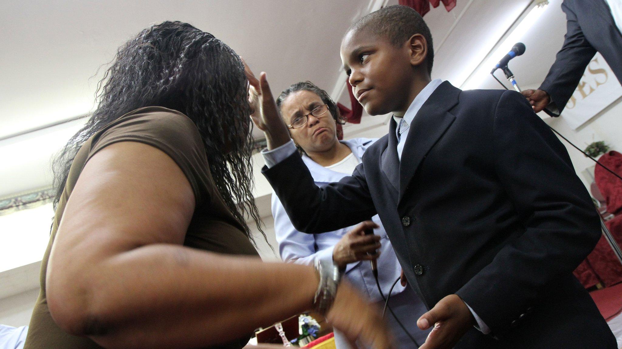 Minister Ezekiel Stoddard blesses a woman after preaching at a church in Washington, DC