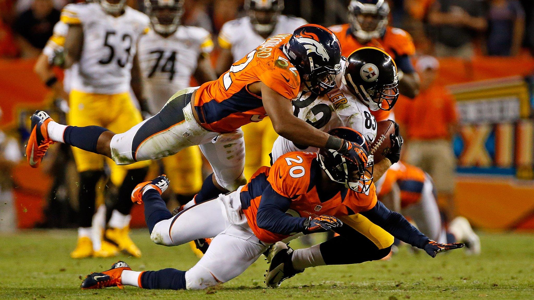 Tight end Heath Miller #83 of the Pittsburgh Steelers makes a reception and is tackled by linebacker Wesley Woodyard #52 and defensive back Mike Adams #20 of the Denver Broncos