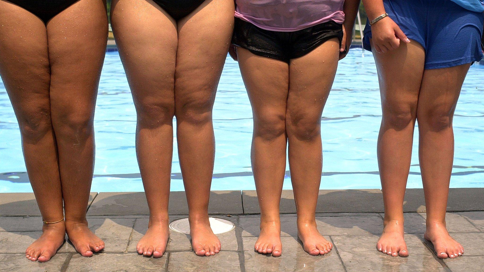 Girls' legs next to swimming pool