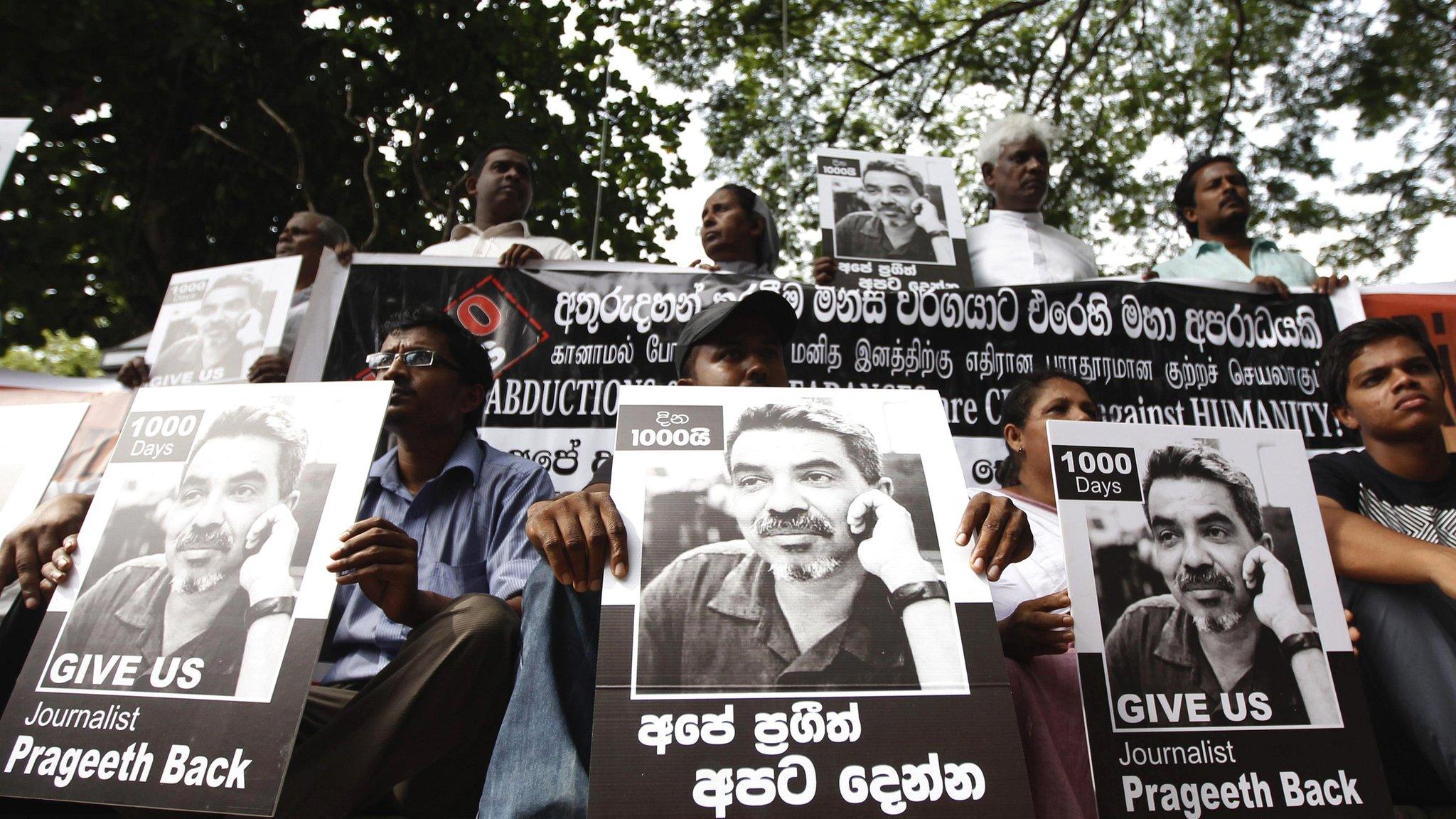 Demonstrators hold placards with an image of missing cartoonist and columnist Prageeth Eknaligoda, during a protest in front of the United Nations head office in Colombo