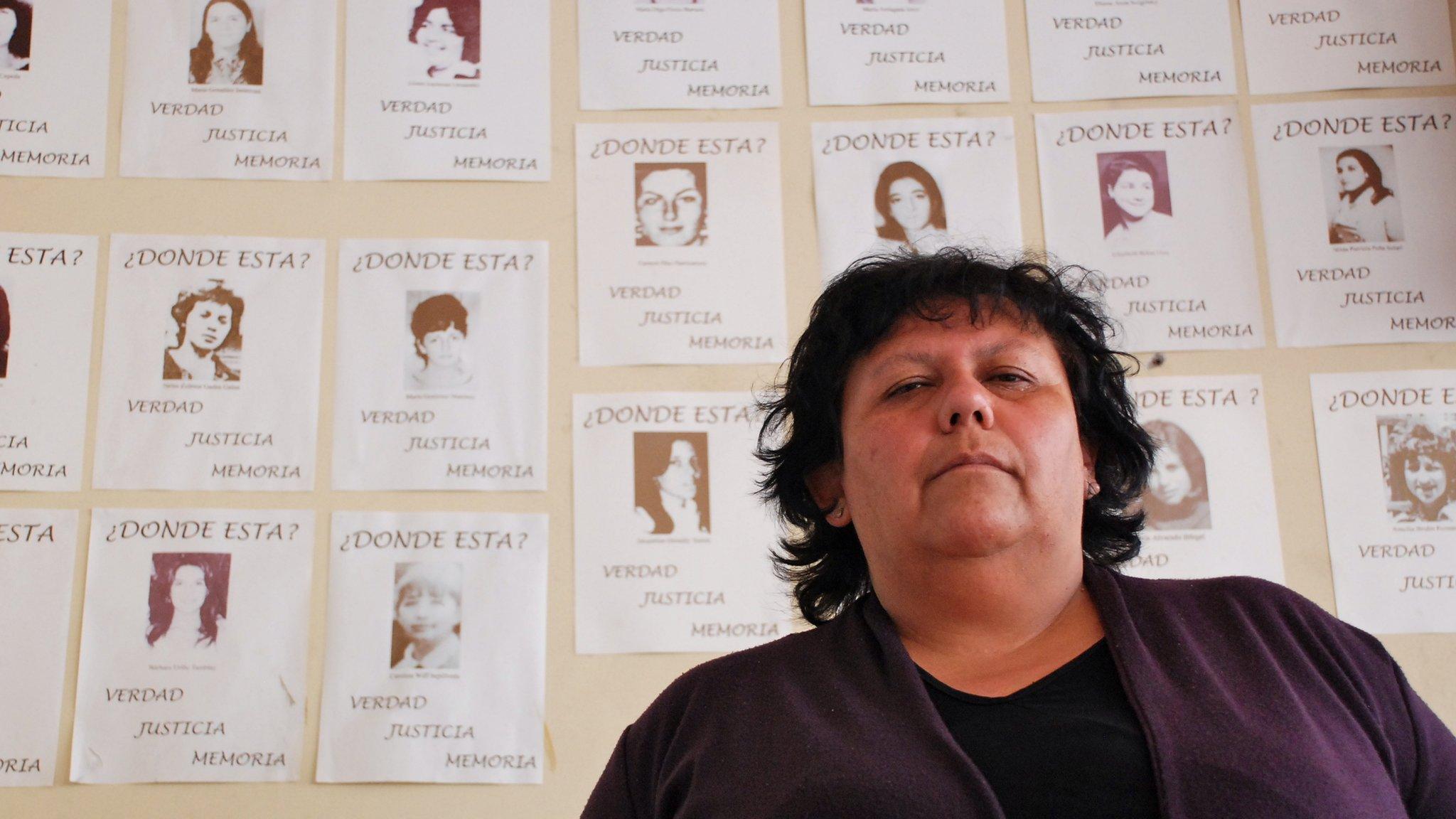 Lorena Pizarro in front of photos of the disappeared in Chile