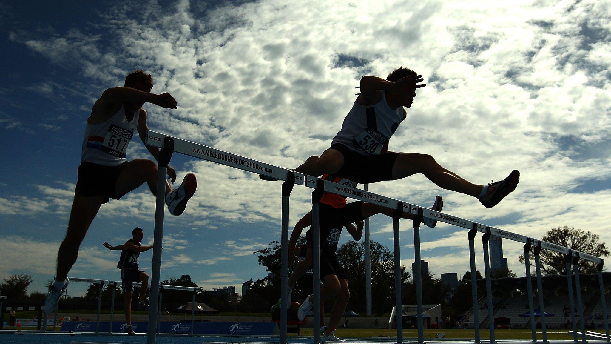 Athletes in Australia jumping over a hurdle