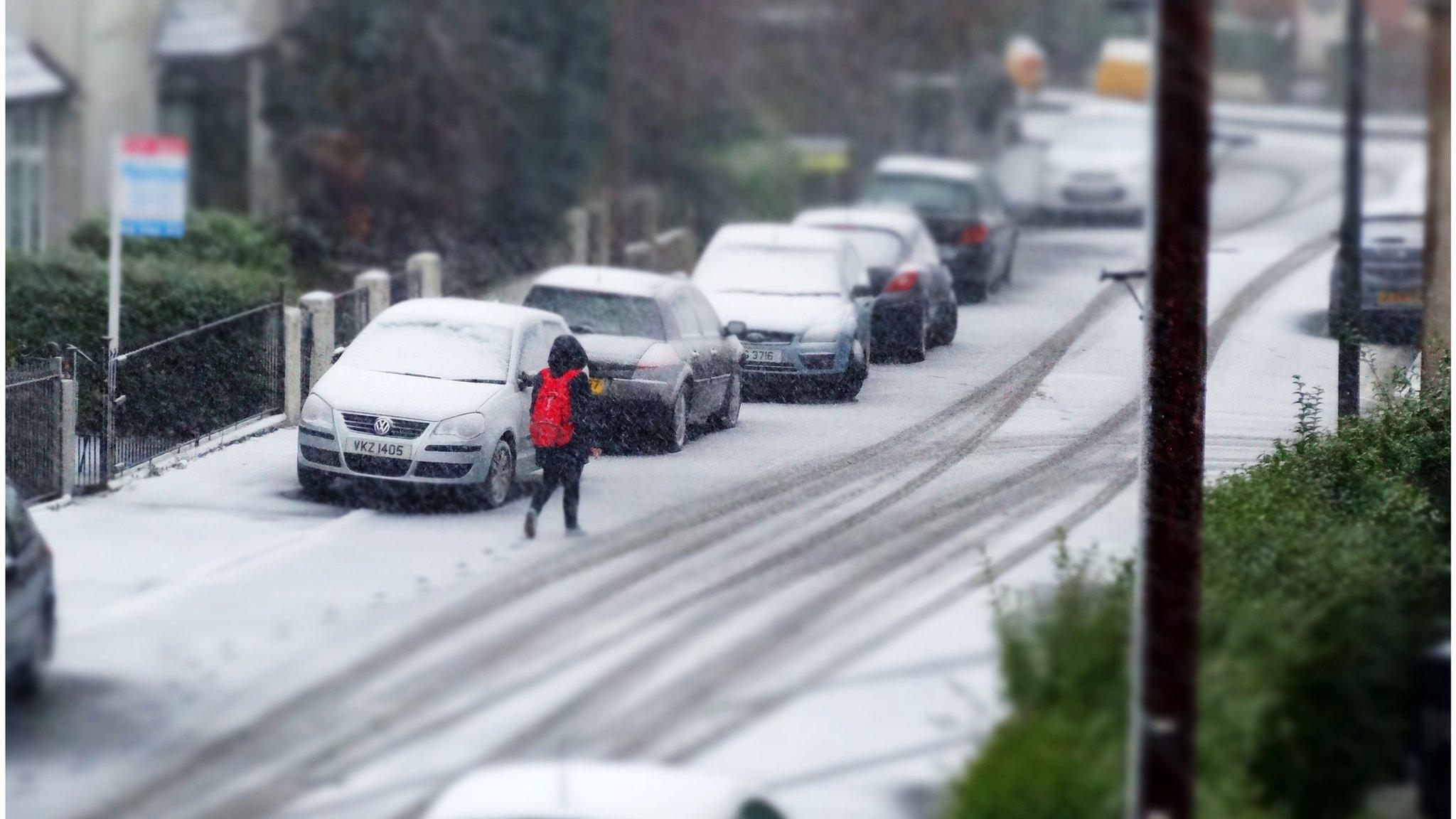 A pedestrian makes her way along snow-covered Ulsterville Avenue in Belfast on Friday