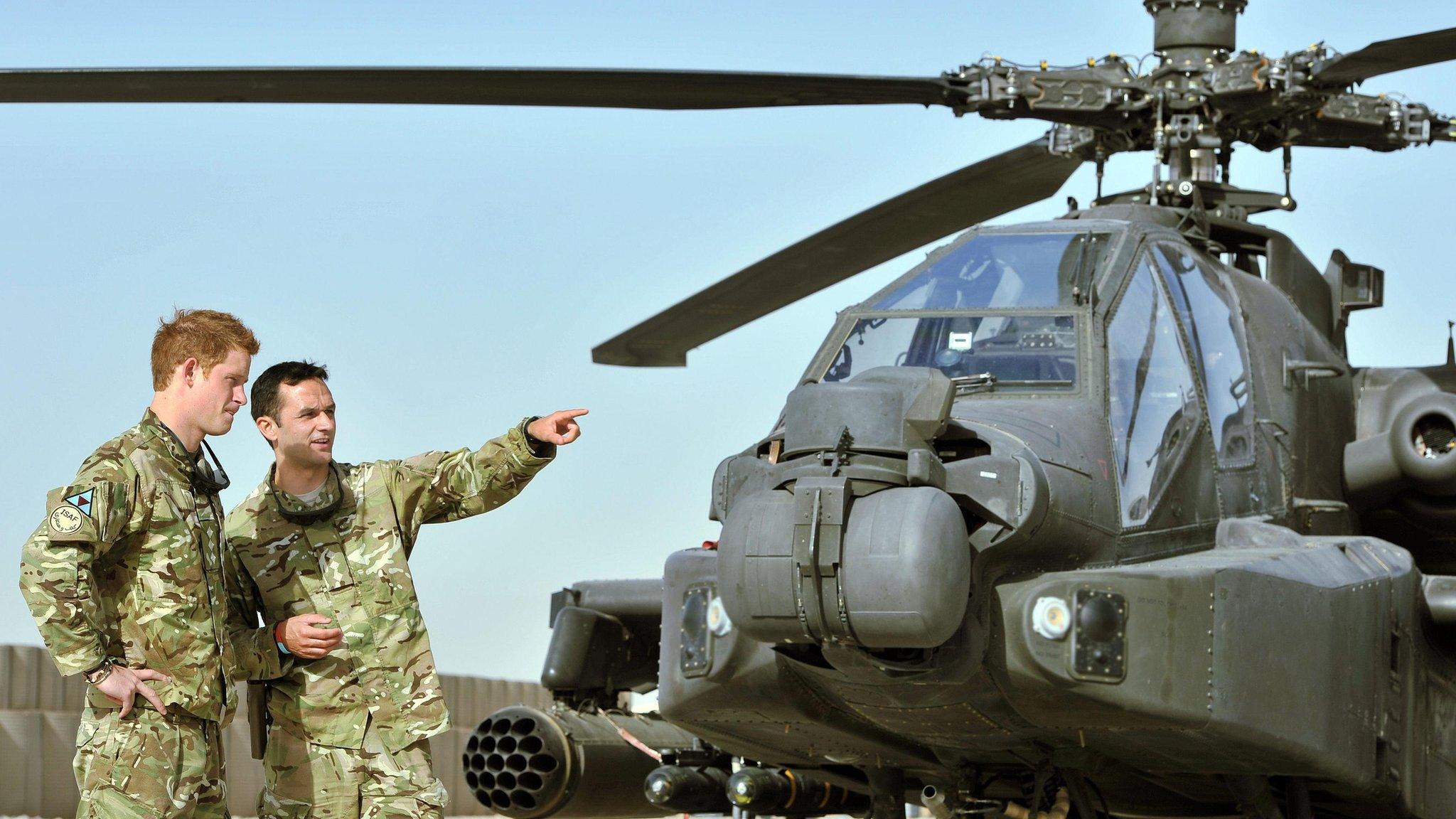 Prince Harry shown the Apache flight-line helicopter by a member of his squadron in September 2012