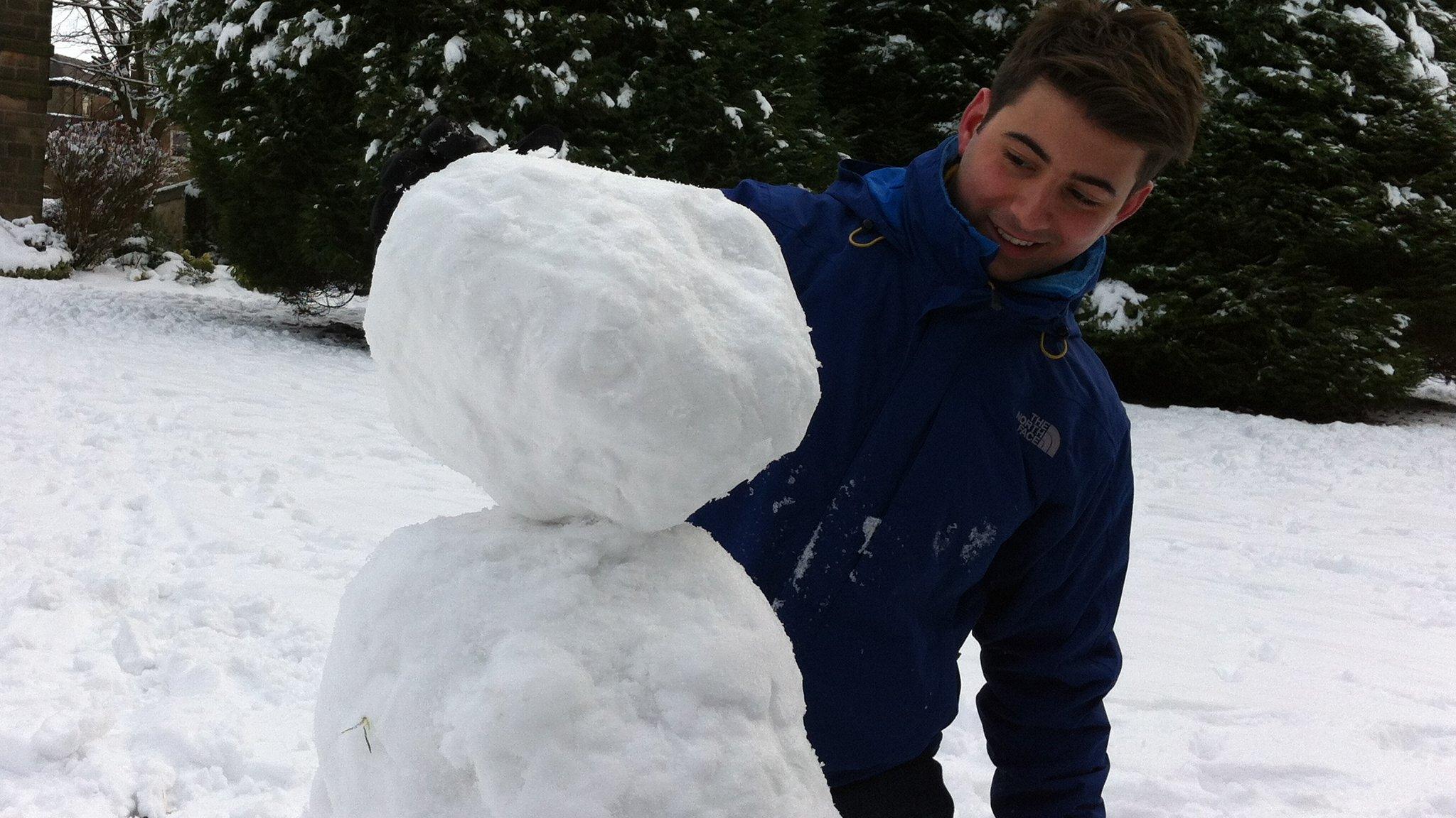 Ricky Boleto puts the head on his snowman.