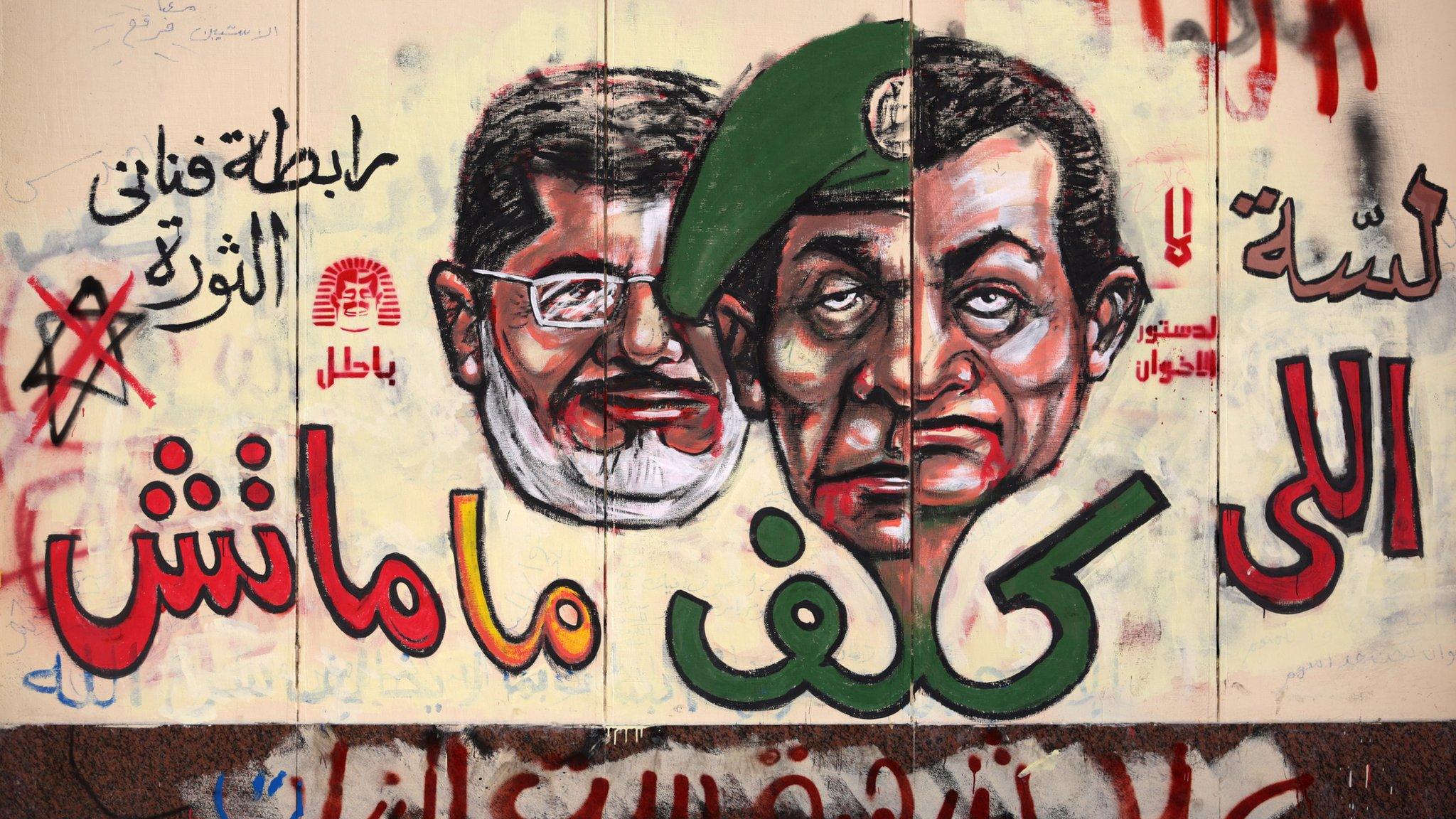 Graffiti showing the face of Mubarak morphing into that of the former military leader, Gen Tantawi with President Morsy behind.