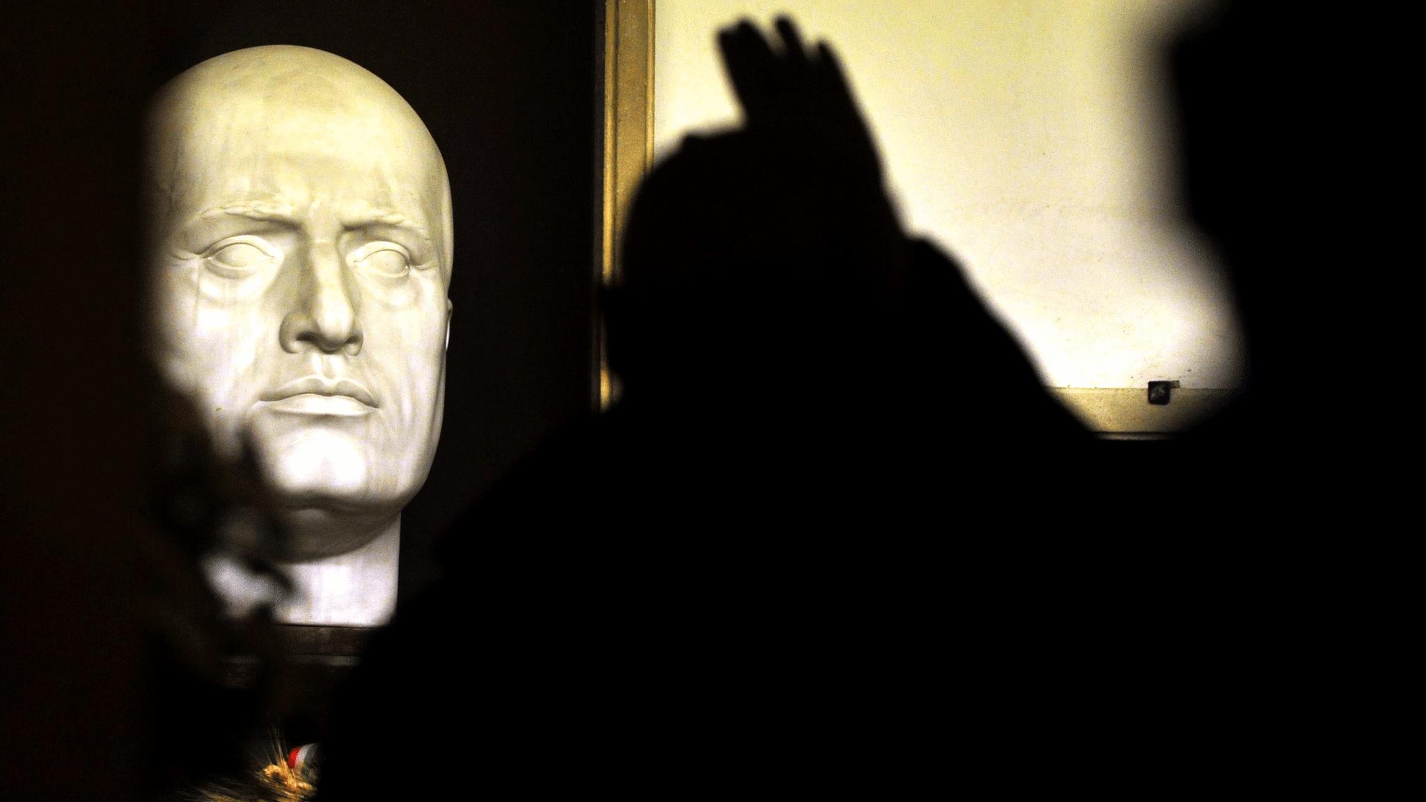 An admirer salutes the bust of Mussolini on his tomb in Predappio, Italy, 28 October 2012