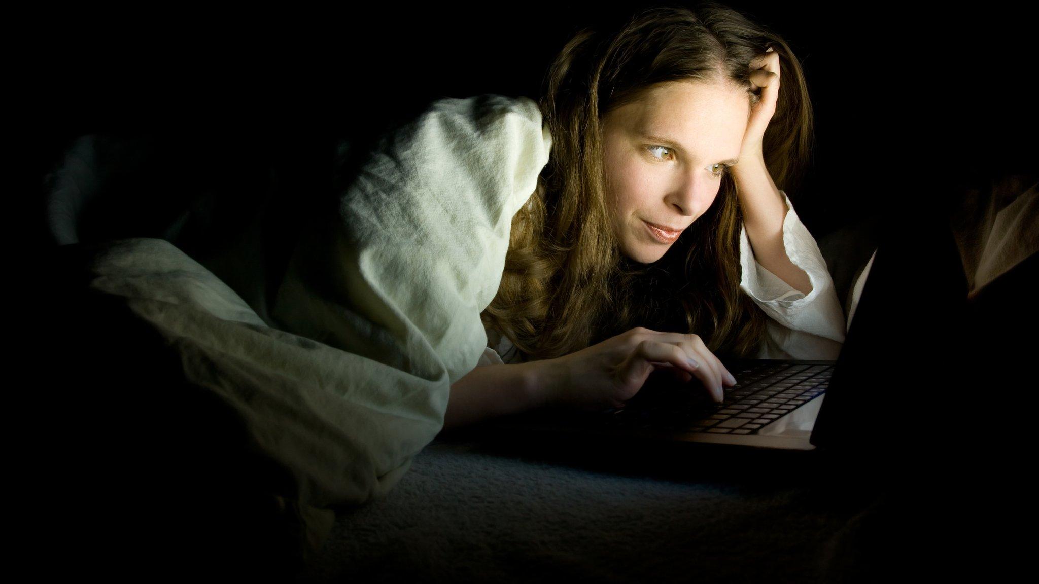 Teenage girl with laptop in bed