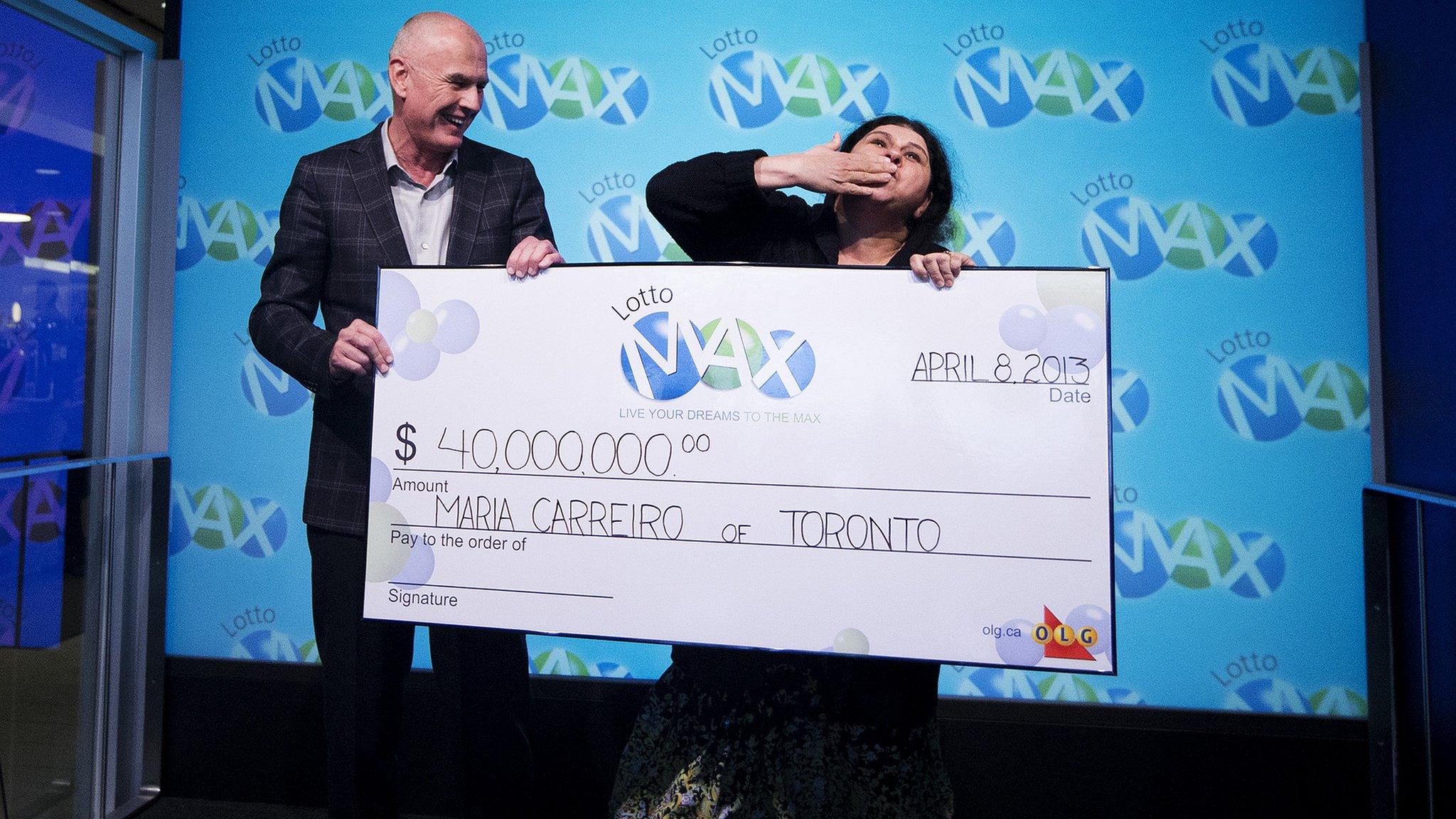 Greg McKenzie, VP of Lottery at OLG, presents a cheque for $40 million to Maria Carreiro 8 April 2013