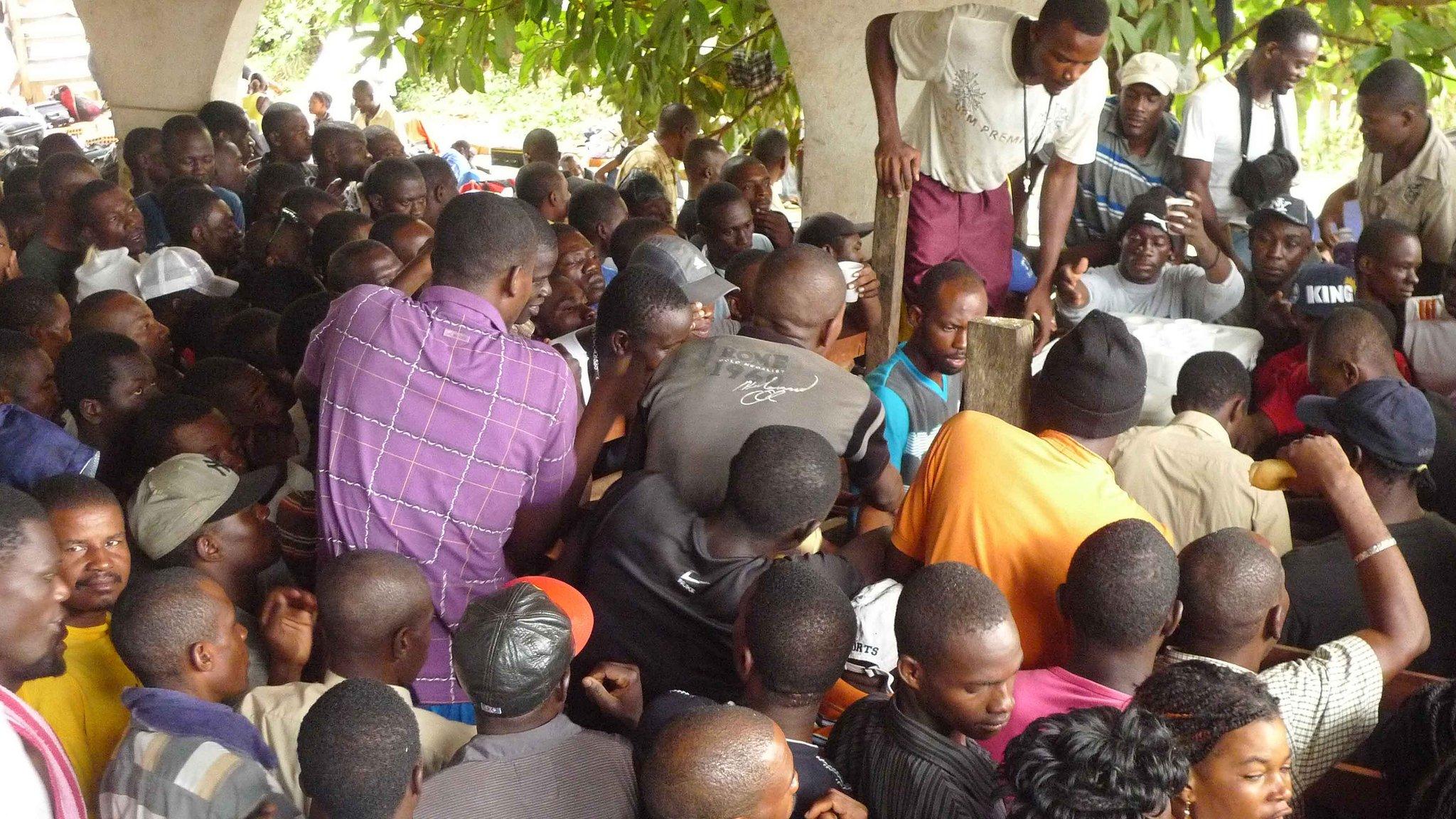 Immigrants waiting for breakfast distribution in Brasileia