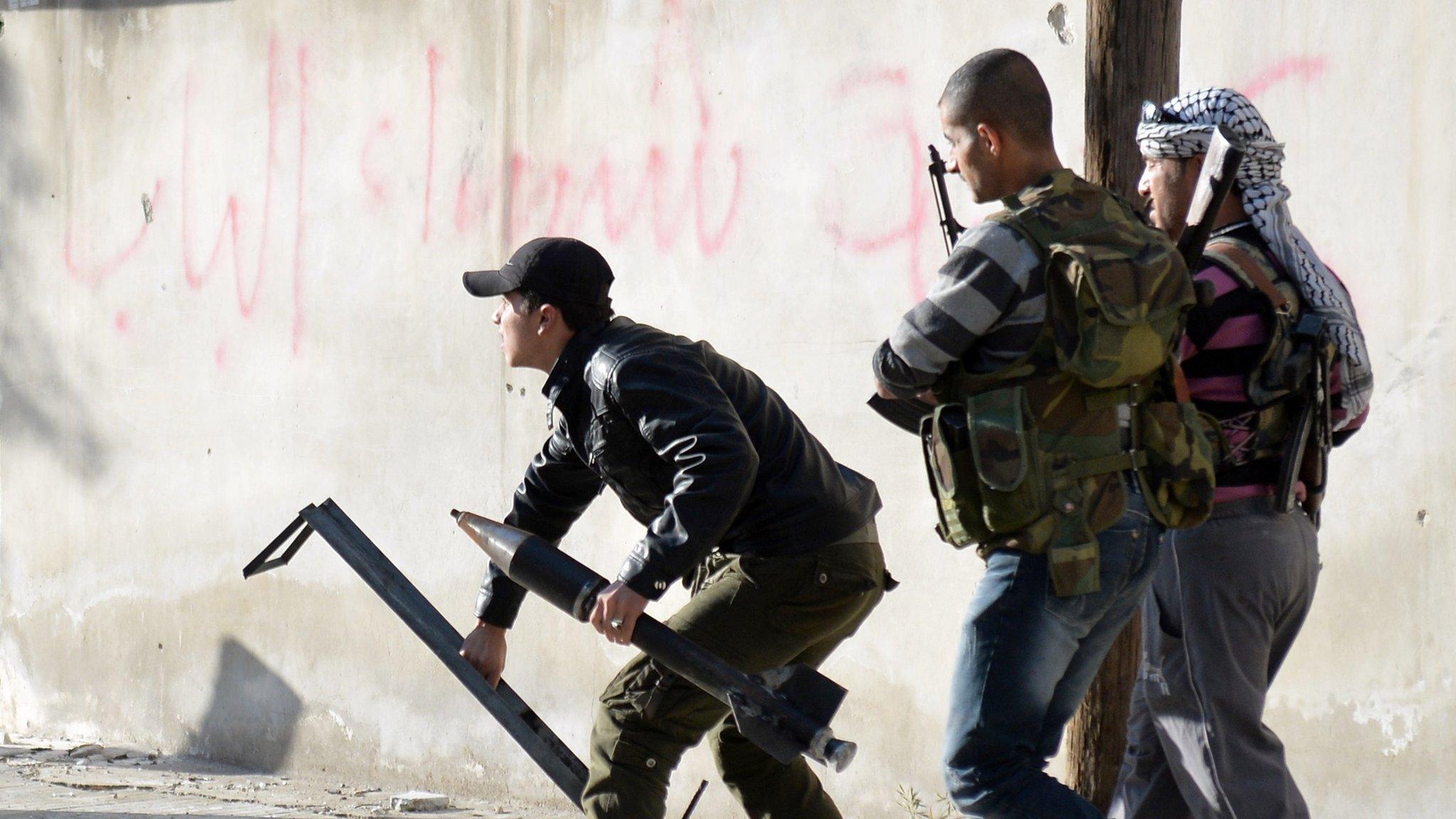 Rebel fighters prepare to launch a rocket in the northern Syrian city of Aleppo on 21 April 2013