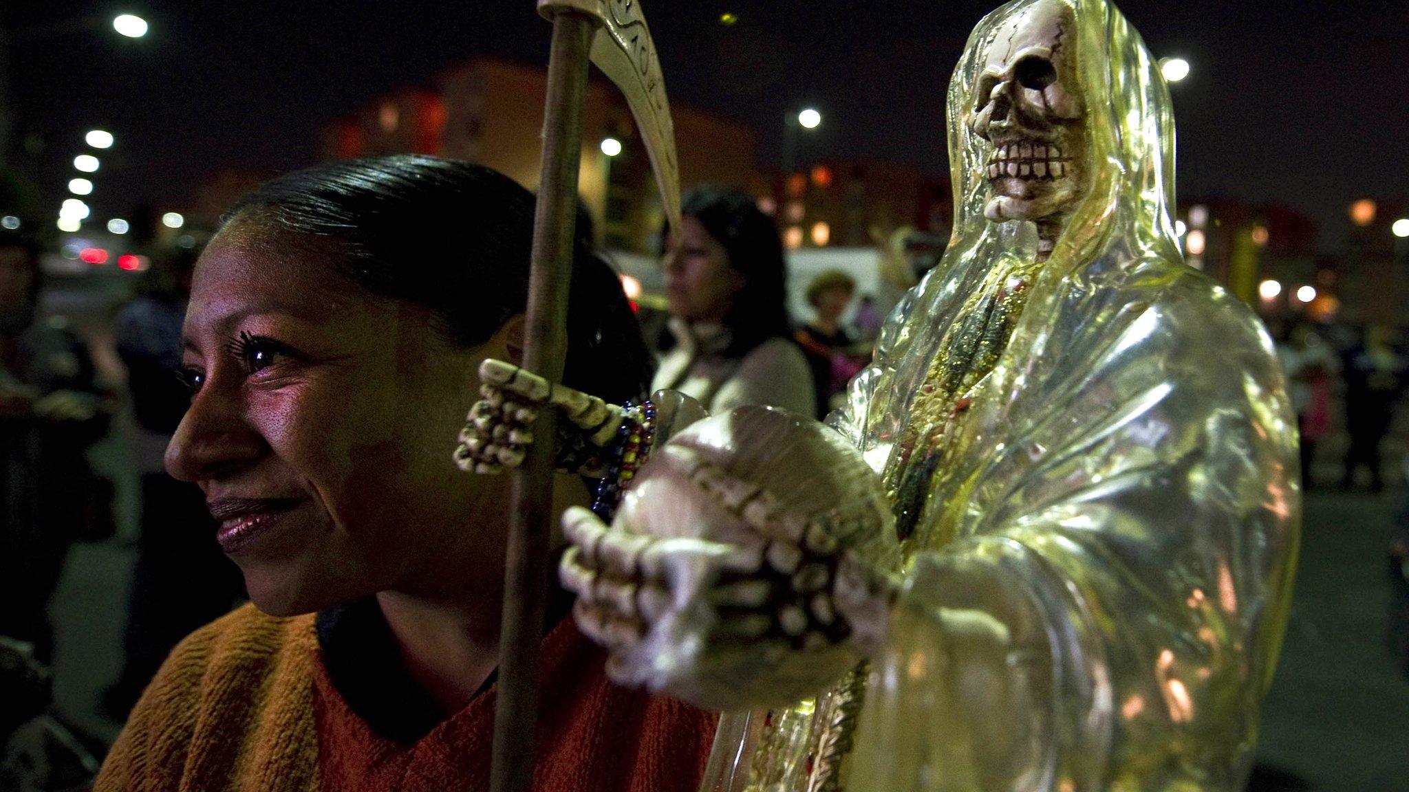 A devotee of Santa Muerte carries a statue on 1 November 2012