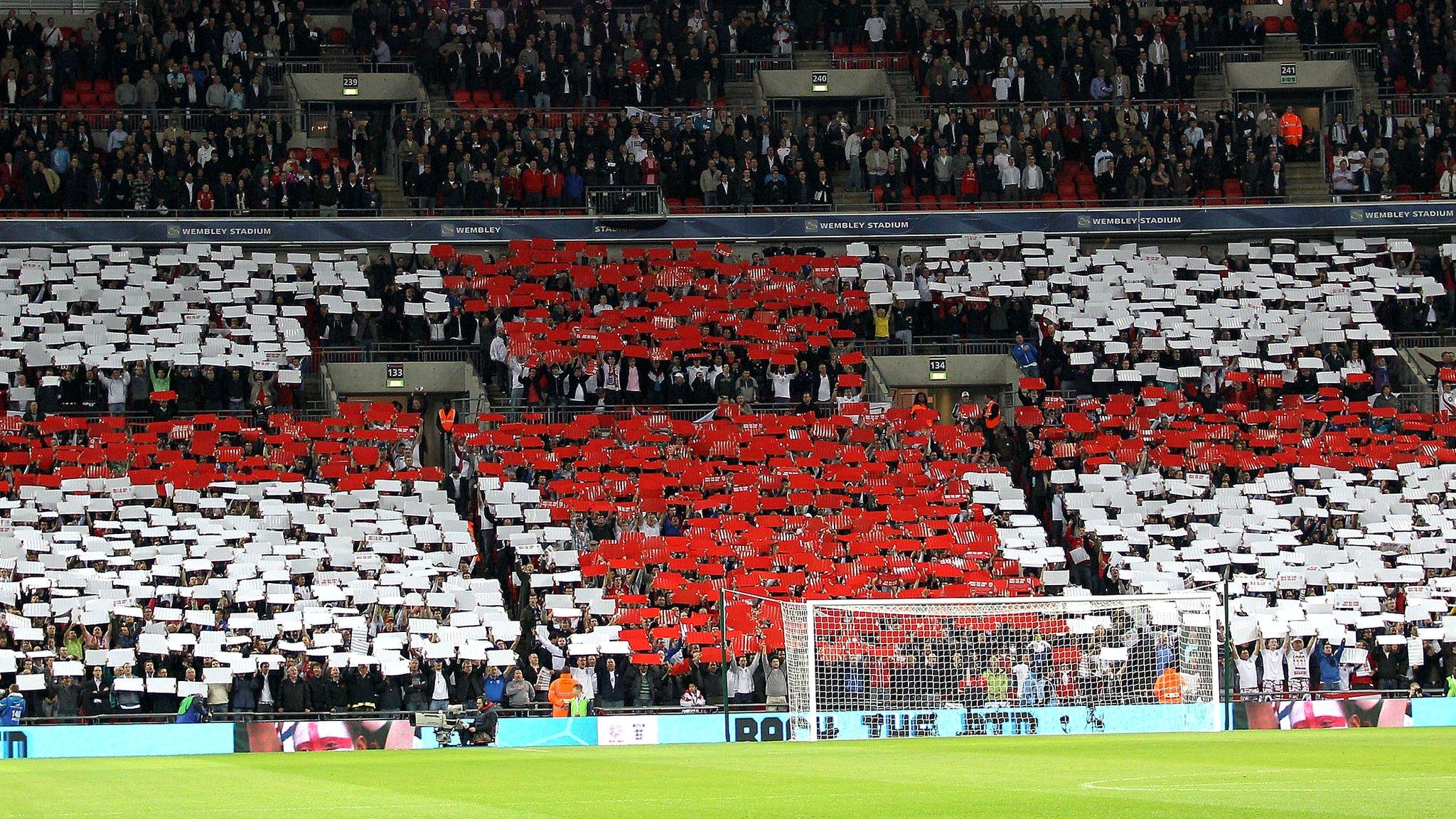 England fans hold up coloured card to create St George's flag at Wembley