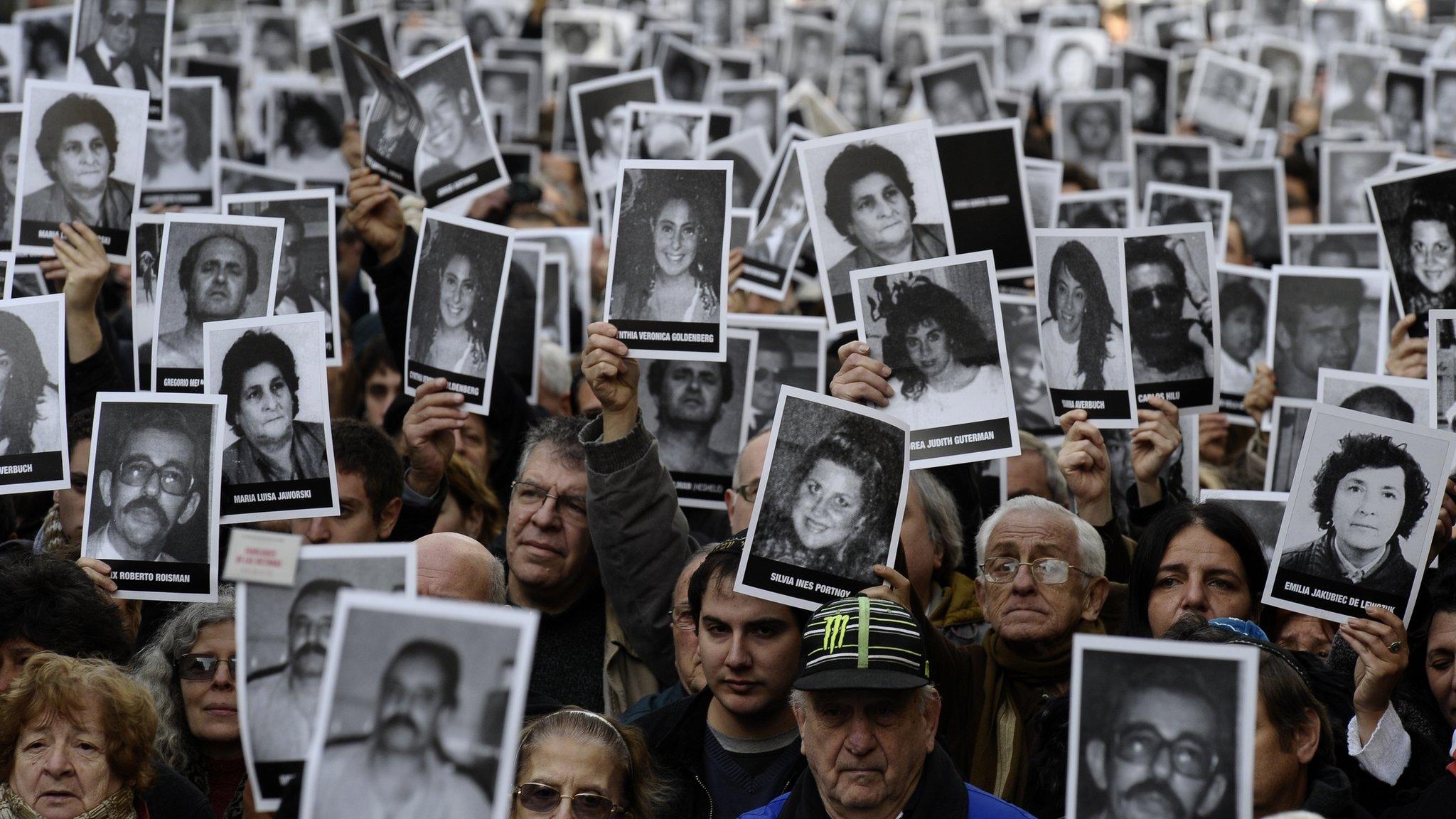 People hold portraits of victims of the terrorist bombing attack against the Argentine Israelite Mutual Association (AMIA) institute that killed 85 people and injured 300, blamed on Iran during the commemoration of its 18th anniversary, in Buenos Aires on 18 July 2012