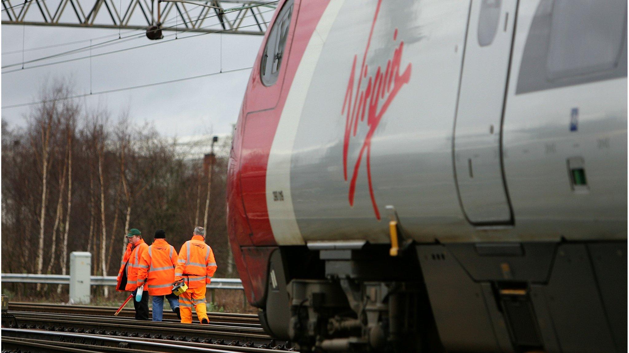 As a Virgin pendolino train passes workers from Network Rail check points and track at Crewe Grand Junction on the West Coast mainline