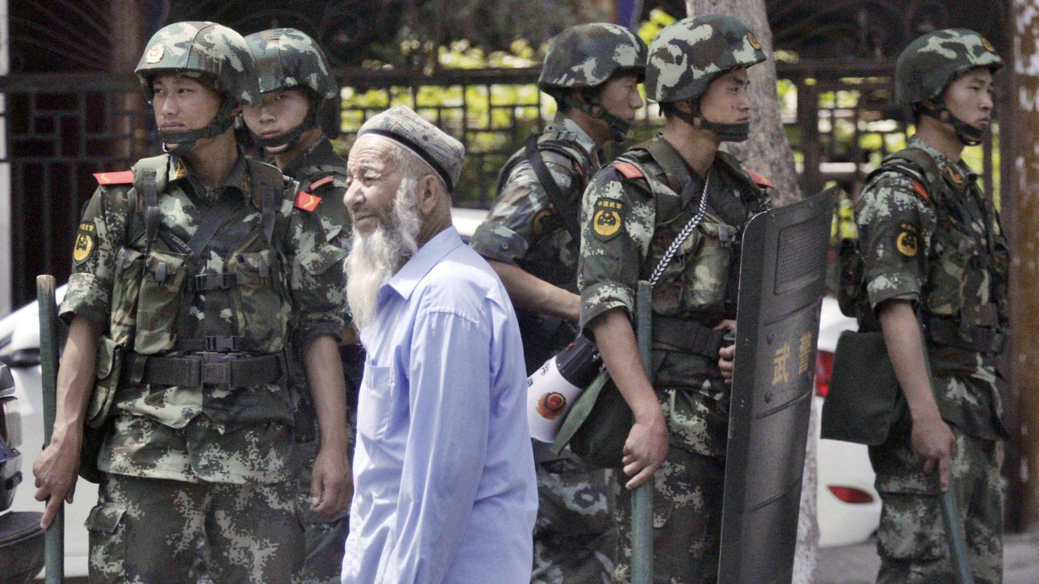 Armed police officers stand guard near the Erdaoqiao Bazaar in Urumqi (June 29, 2013)