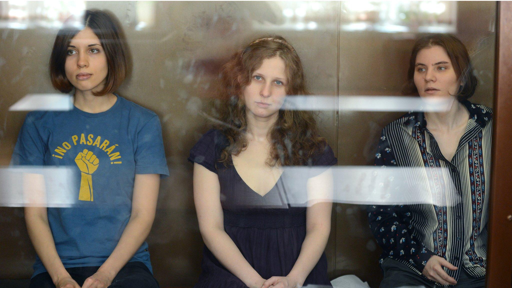 Pussy Riot members Nadezhda Tolokonnikova (L), Maria Alyokhina (C) and Yekaterina Samutsevich (R) in a glass enclosure during a court hearing in Moscow