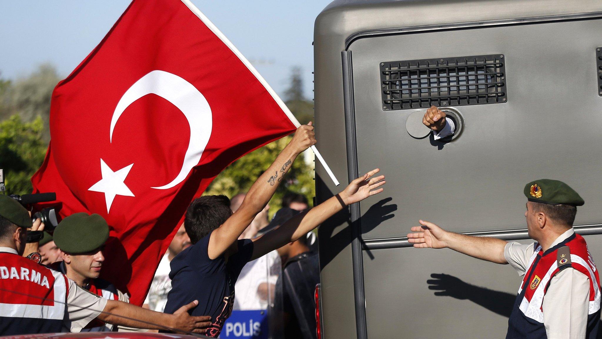 Protesters run after a prison van as an unidentified defendant sticks his fist out, near the courthouse in Silivri - 2013 pic