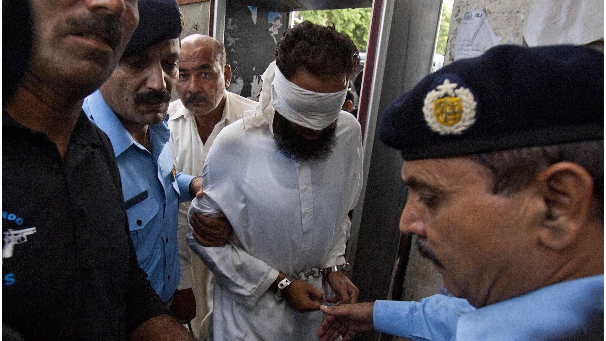 Muslim cleric Khalid Jadoon (blindfolded) is escorted by police in Islamabad (2 Sept 2012)