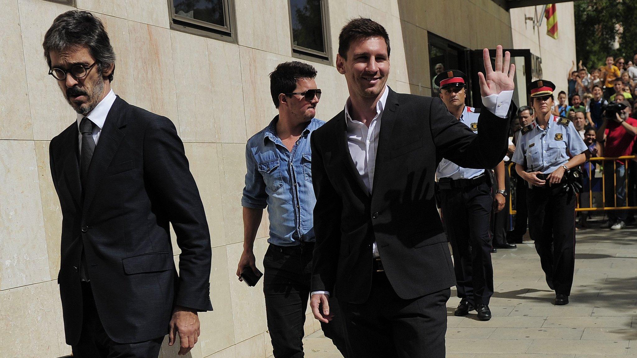 Barcelona football star Lionel Messi (C), his brother Rodrigo and lawyer Cristobal Martell (L) leave the courthouse in the coastal town of Gava near Barcelona (27 September 2013)