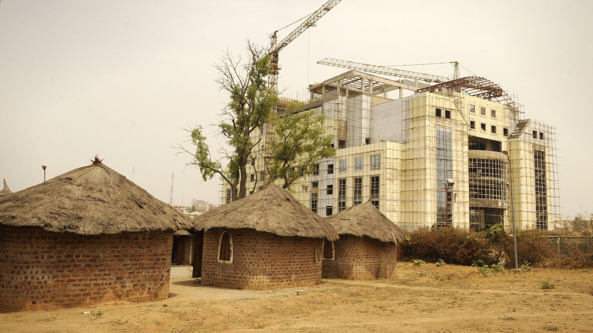 Old dwellings next to enormous building site