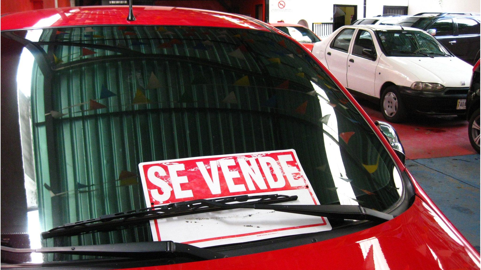 A 'For sale' sign on a car at used car dealership in Caracas, Venezuela