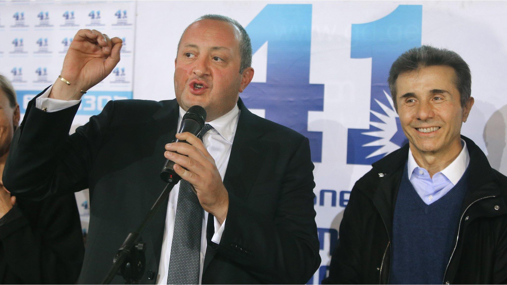 Georgia's Prime Minister Bidzina Ivanishvili, right, and presidential candidate Giorgi Margvelashvili, left, greet supporters at the Georgian Dream coalition headquarters in Tbilisi, Georgia (27 Oct. 2013)