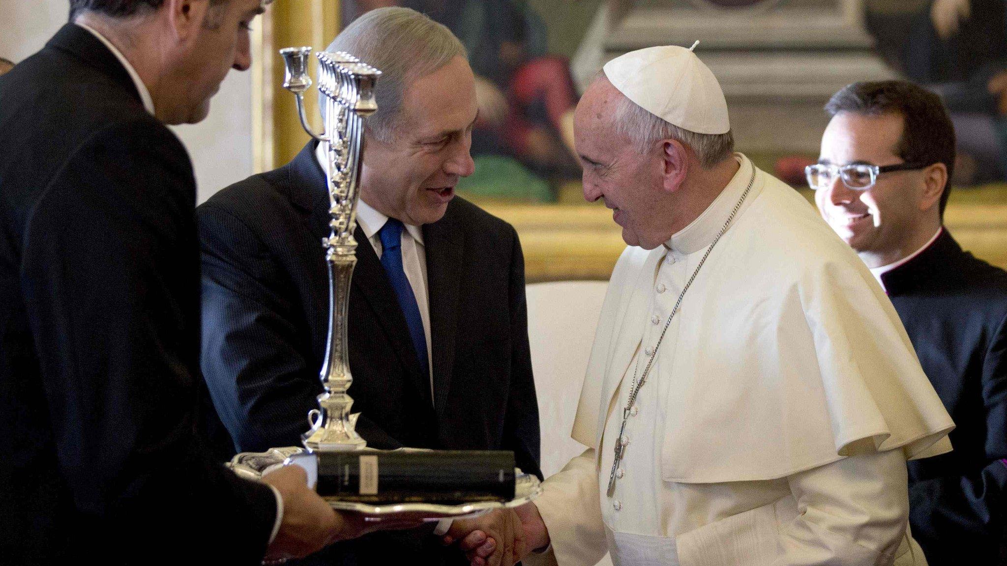 Pope Francis (L) talks with Israeli Prime Minister Benjamin Netanyahu as he was presented with a Menorah during a private audience at the Vatican December 2, 2013