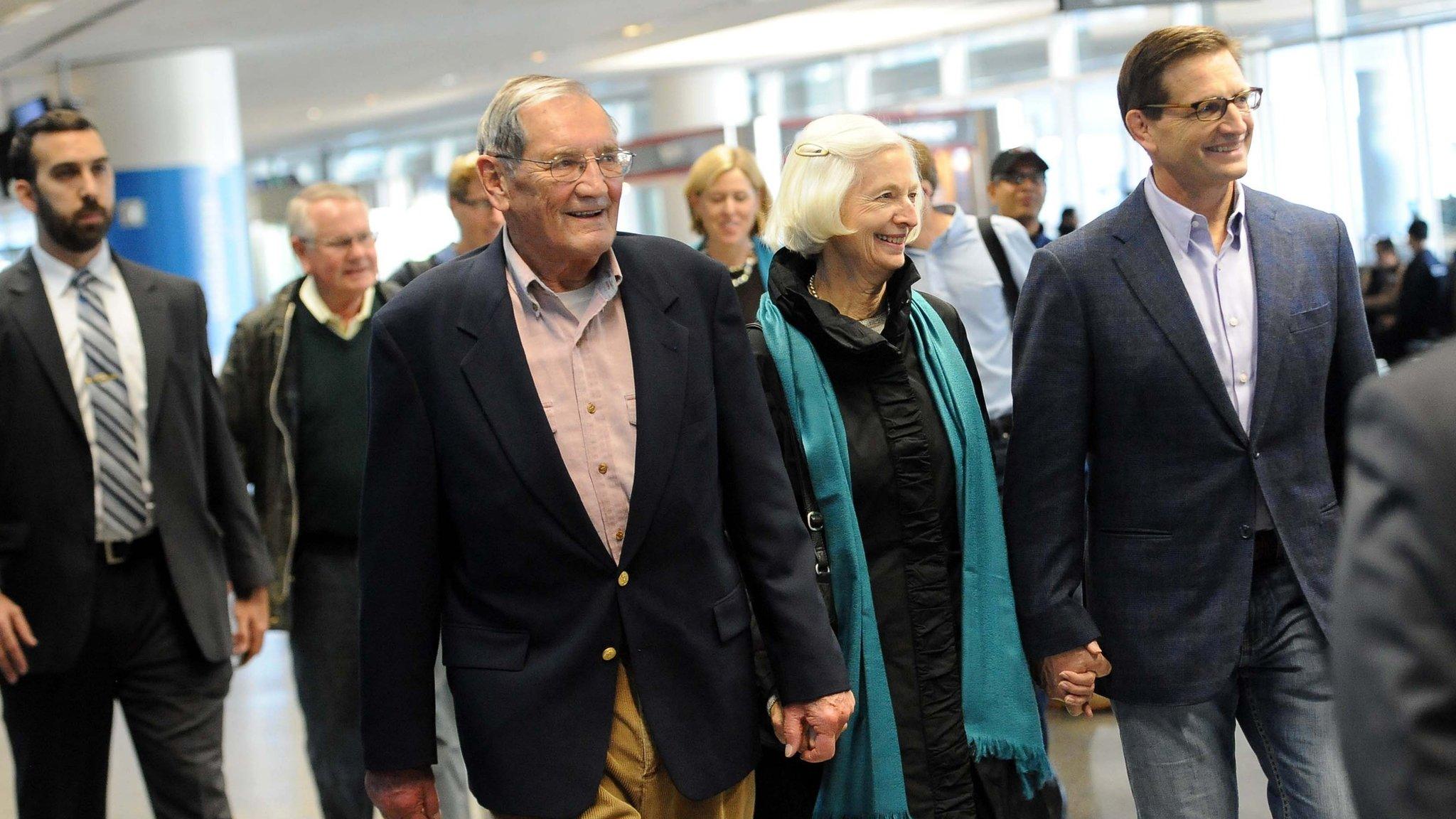 Korean War veteran Merrill Newman (C-L), 85, walks with his wife Lee (C-R) and son Jeff (R) after arriving at San Francisco International Airport on December 7, 2013 following his release from detention in North Korea