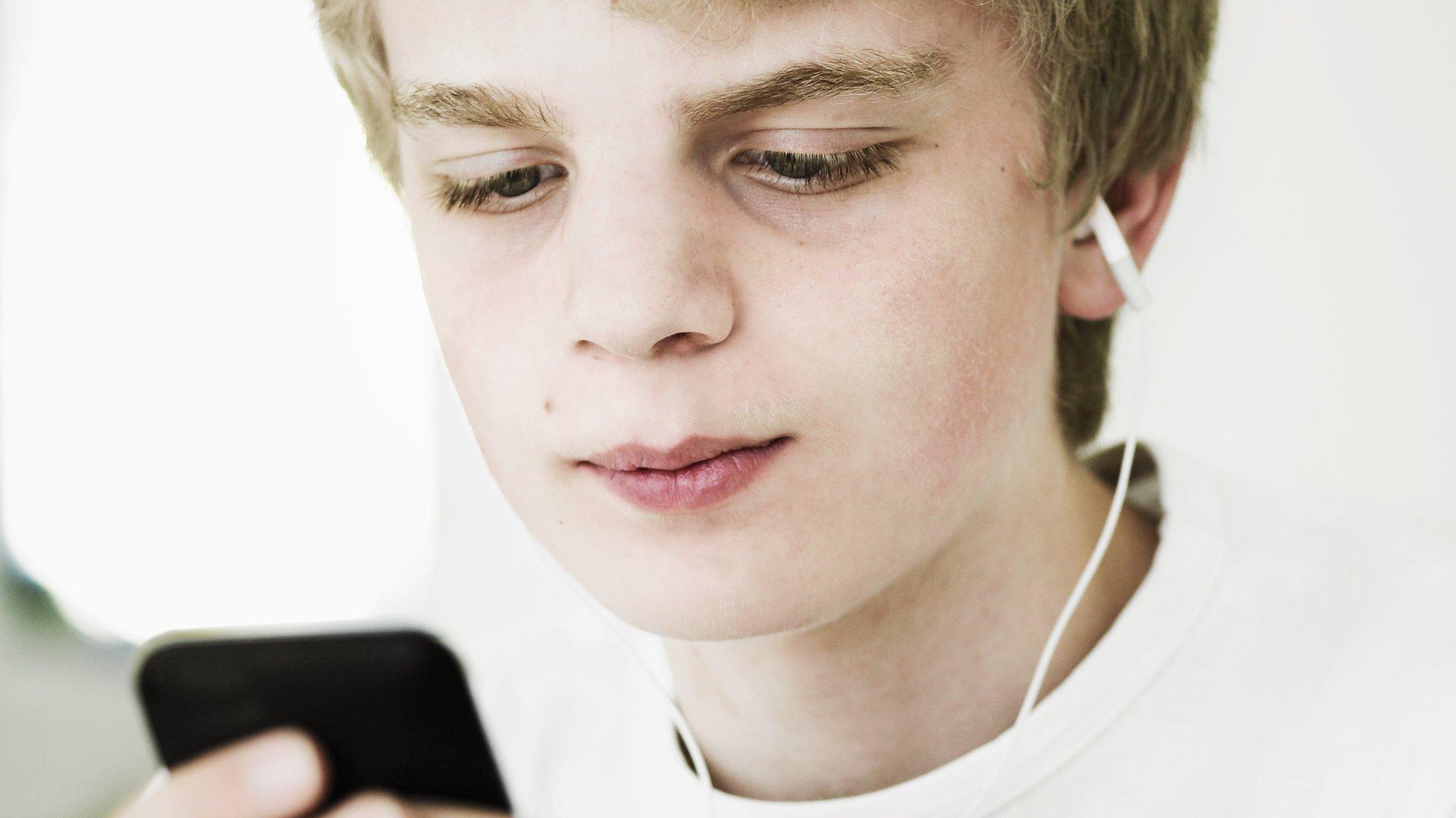boy listing to music using his phone