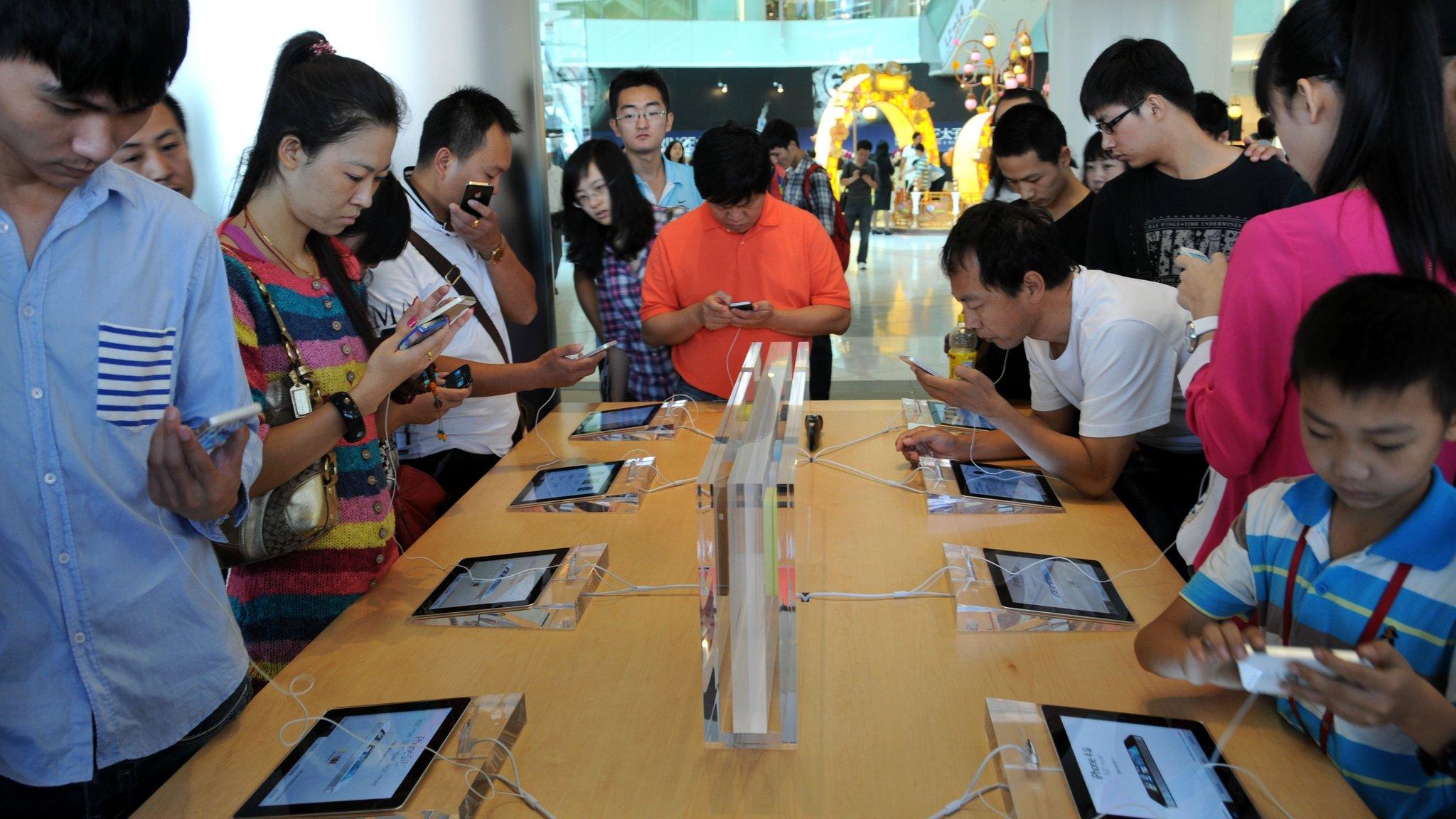 Customers looking at iPhones at an Apple store in China