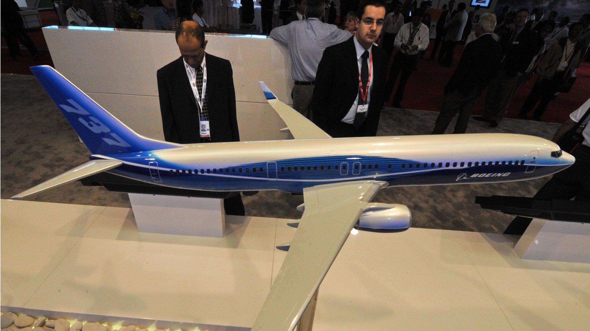 People looking at a model of Boeing 737 plane