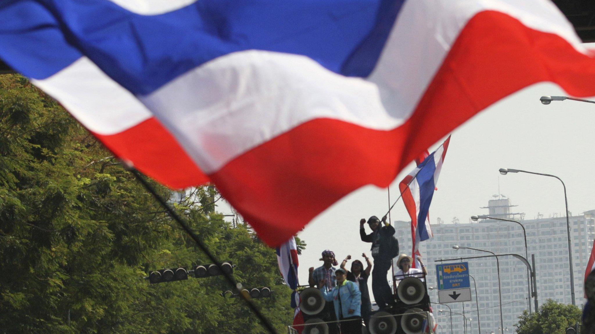 Anti-government protesters wave their national flags during a rally in Bangkok