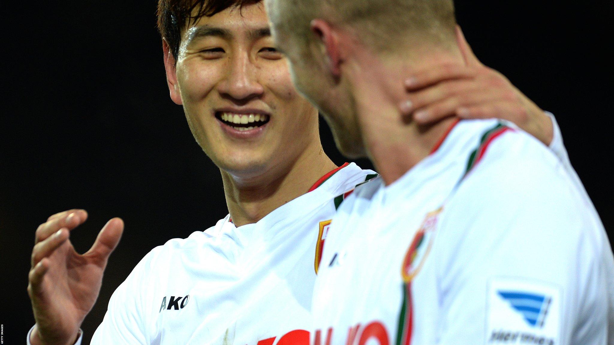 Ji Dong-Won, left, celebrates scoring FC Augsburg's equaliser at Borussia Dortmund.