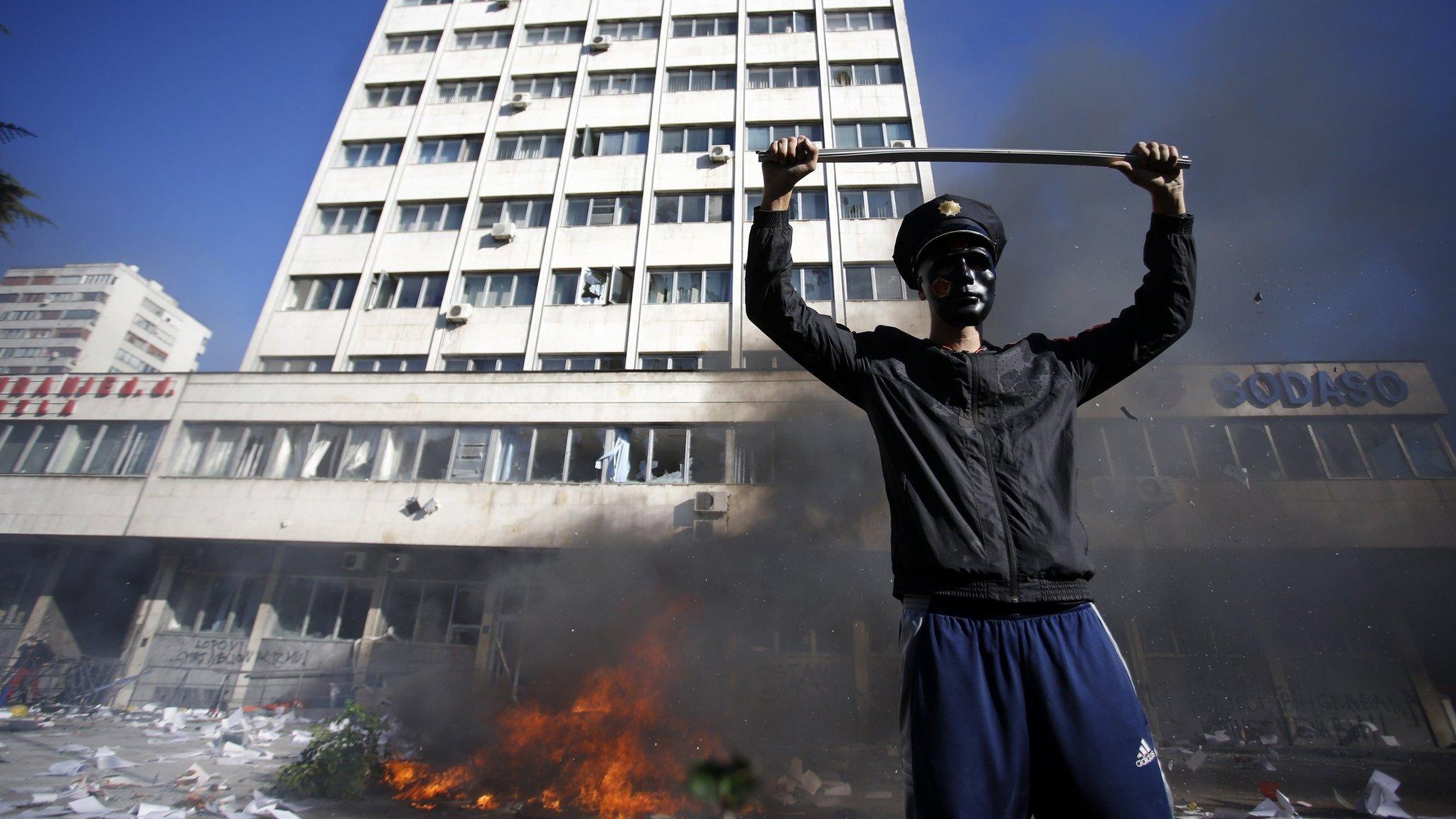 A protester stands near a fire set in front of a government building in Tuzla February 7, 2014