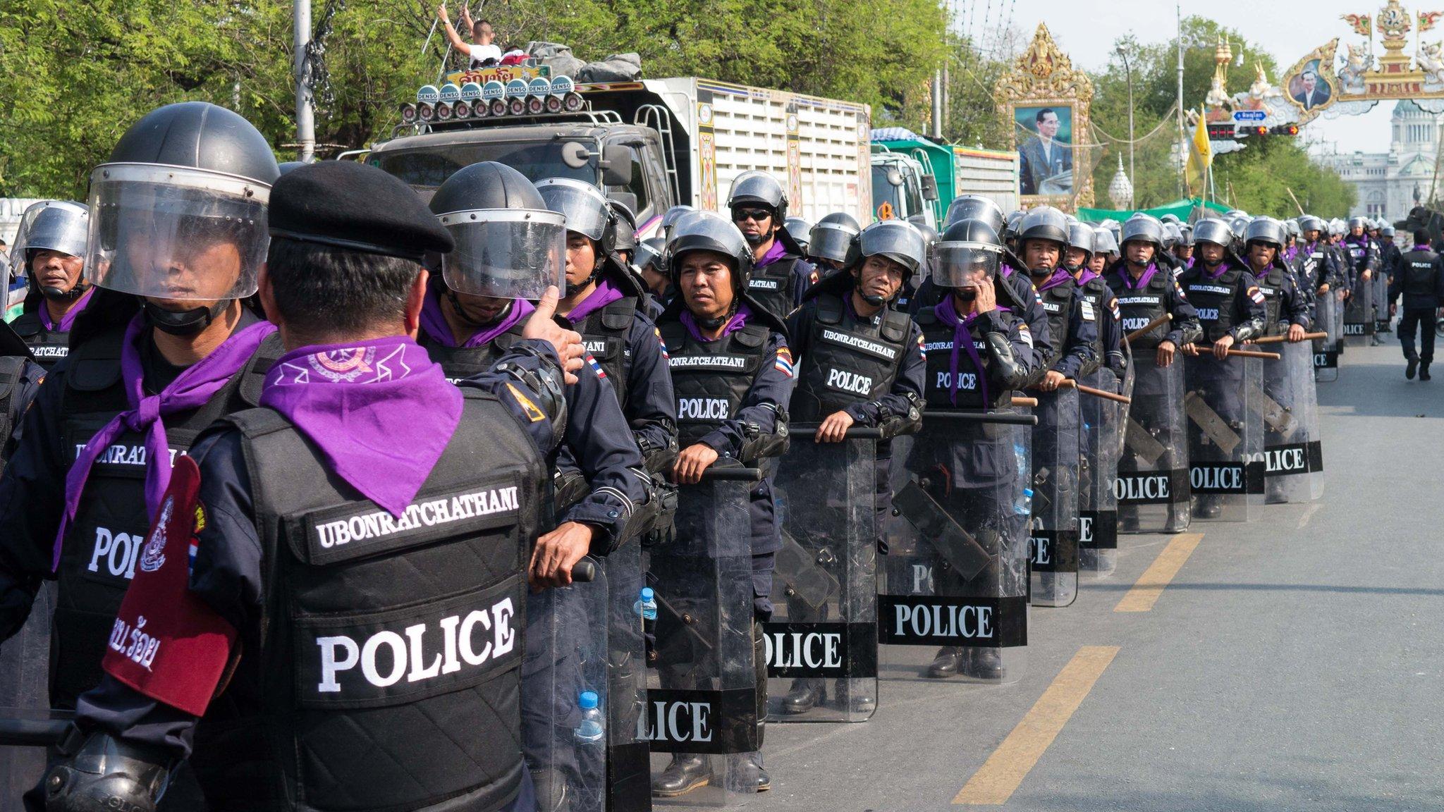 Police wait at the Rachadamnoen, Bangkok, on 14 February 2014