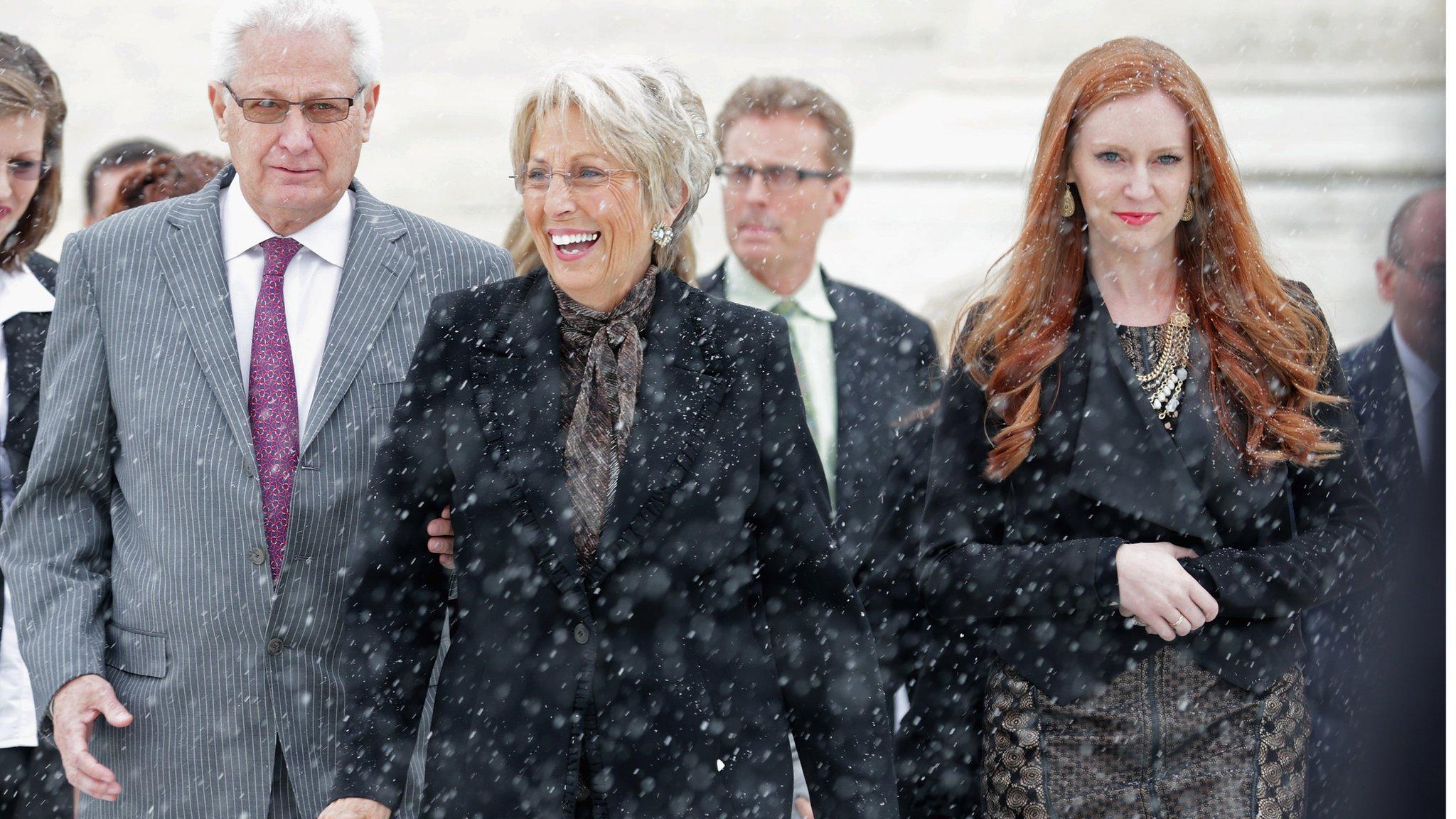 Hobby Lobby co-founders David Green (L) and Barbara Green (C) leave the U.S. Supreme Court after oral arguments in Sebelius v Hobby Lobby