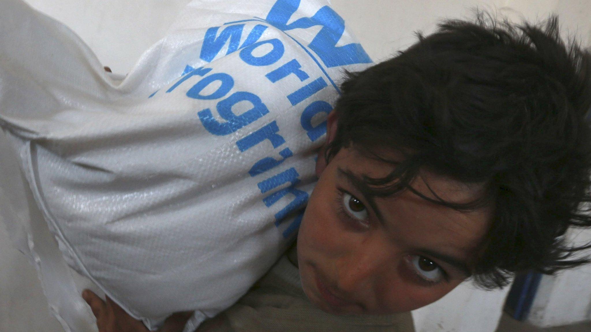 A boy receives humanitarian aid in Duma, Damascus March 29, 2014