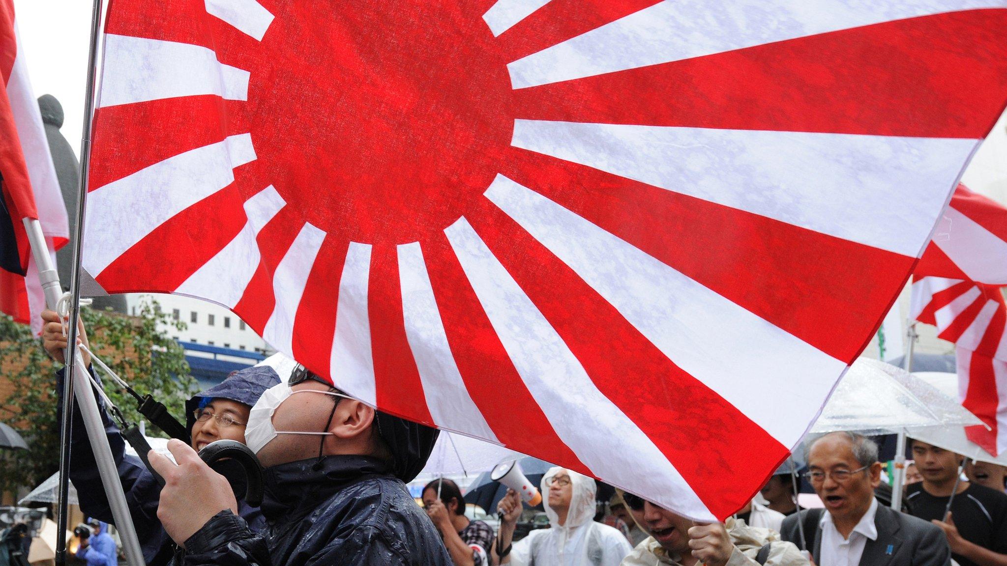 This picture taken on 23 September 2012 shows members of a right wing group raising Japan's rising sun flag during a rally in Tokyo